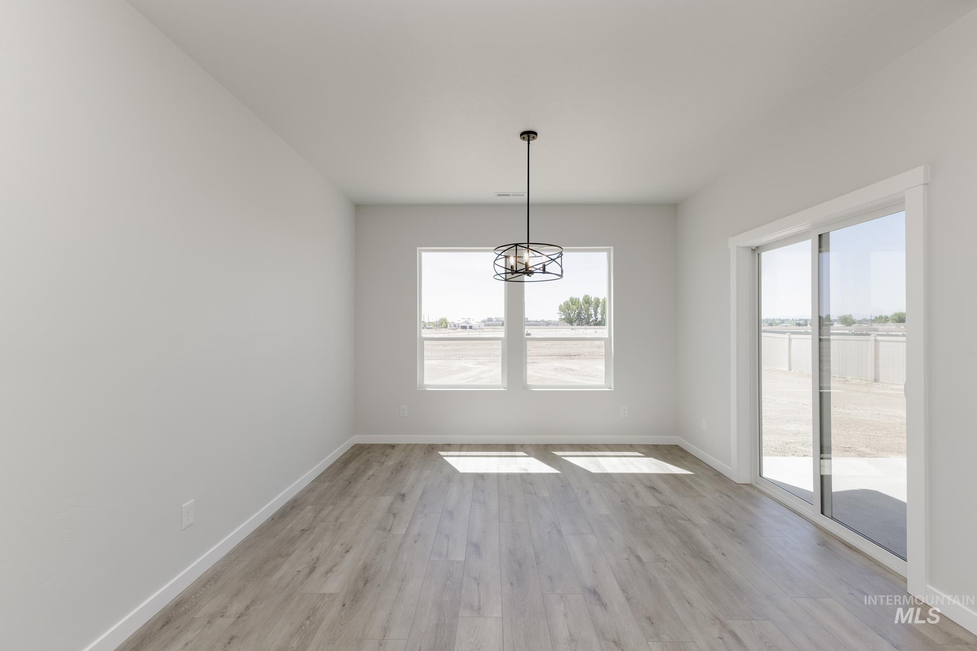 Unfurnished dining area with light wood-style flooring and a chandelier