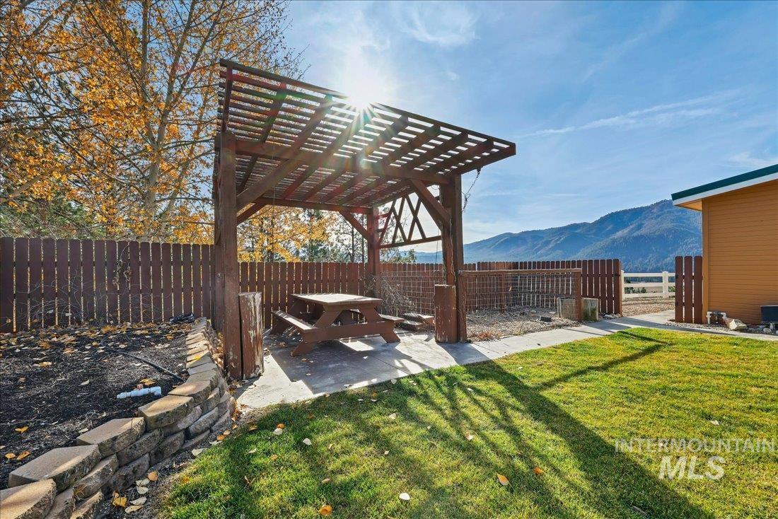 Fenced backyard with a mountain view, a patio, and a pergola