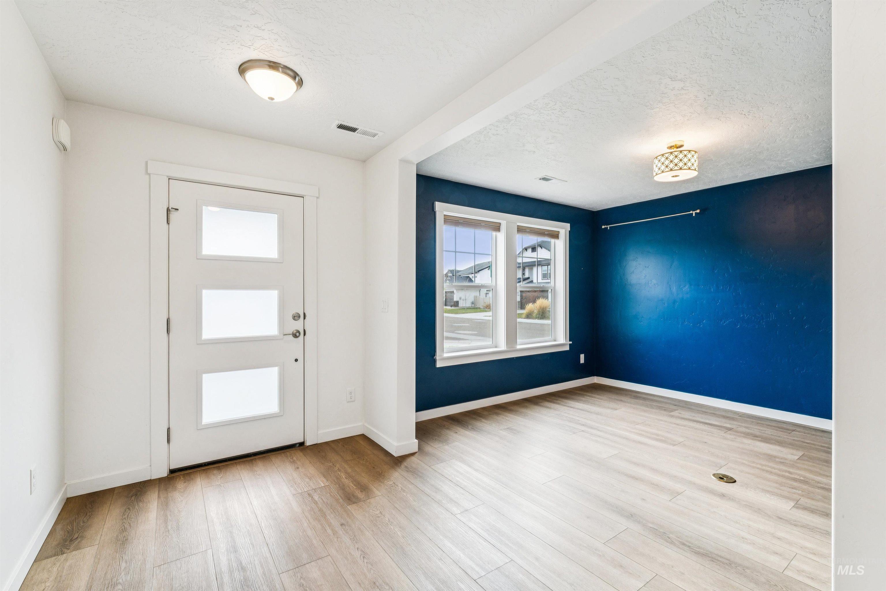 Foyer featuring light wood finished floors and a textured ceiling