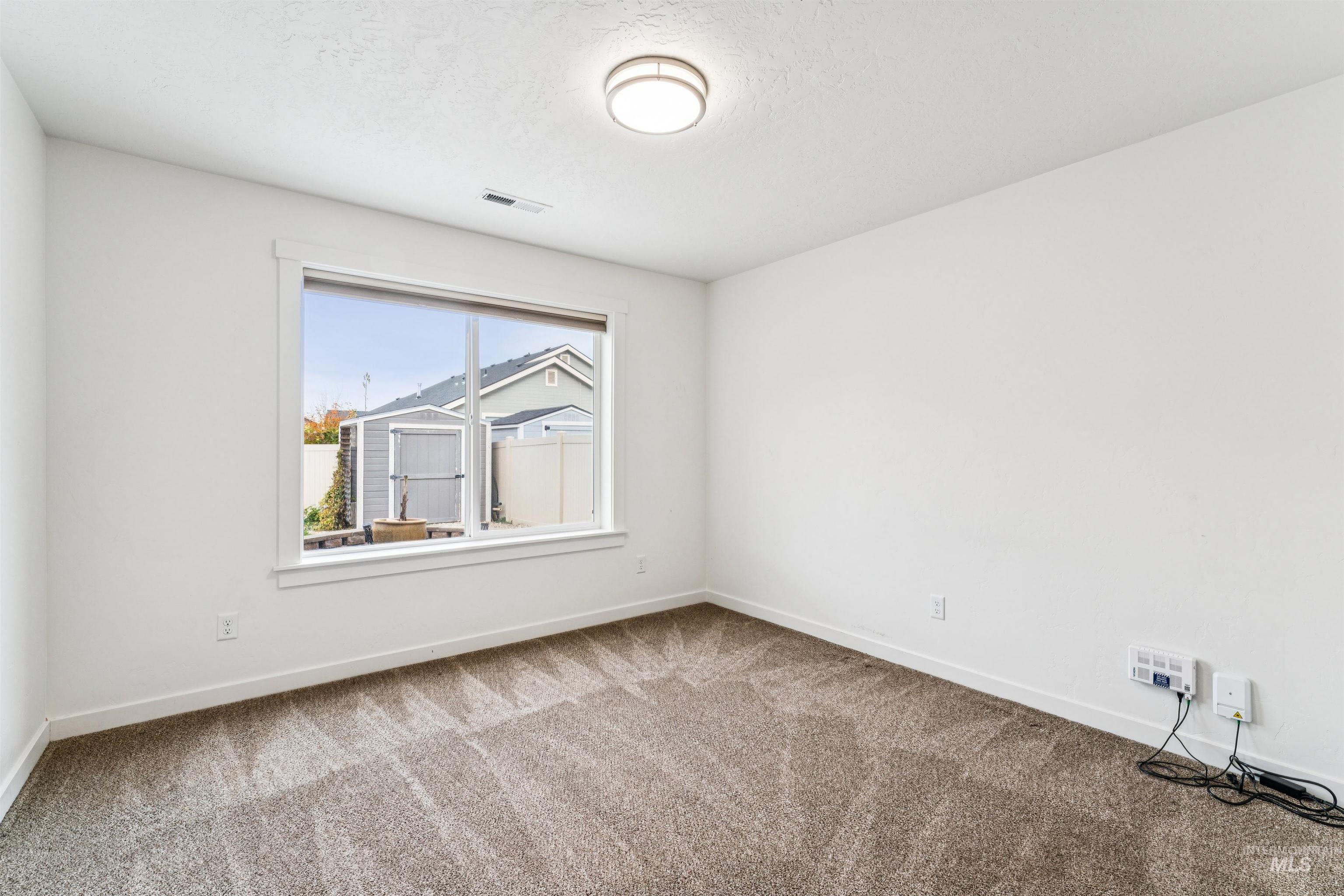 Spare room with carpet flooring and a textured ceiling