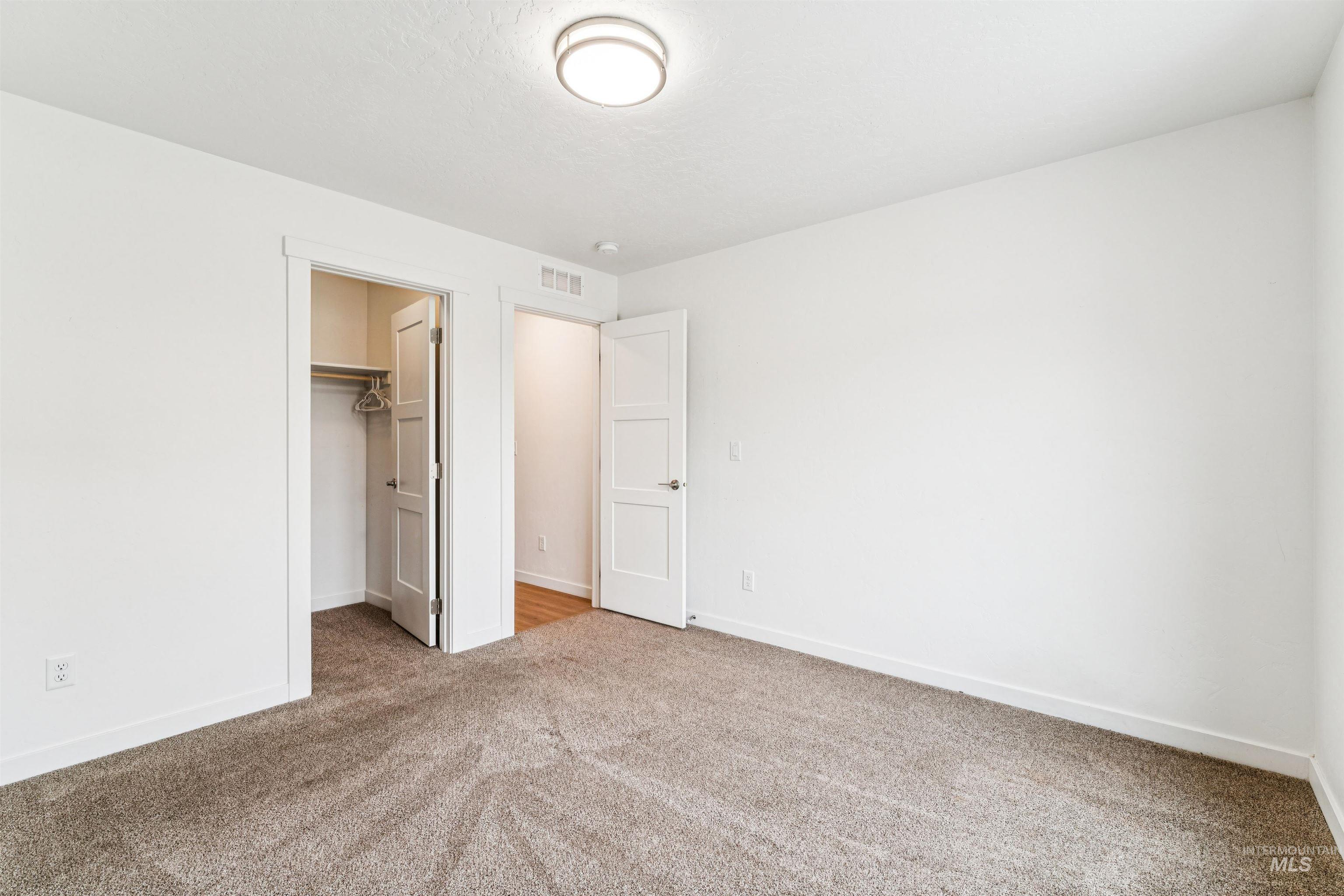 Unfurnished bedroom featuring a spacious closet and carpet flooring
