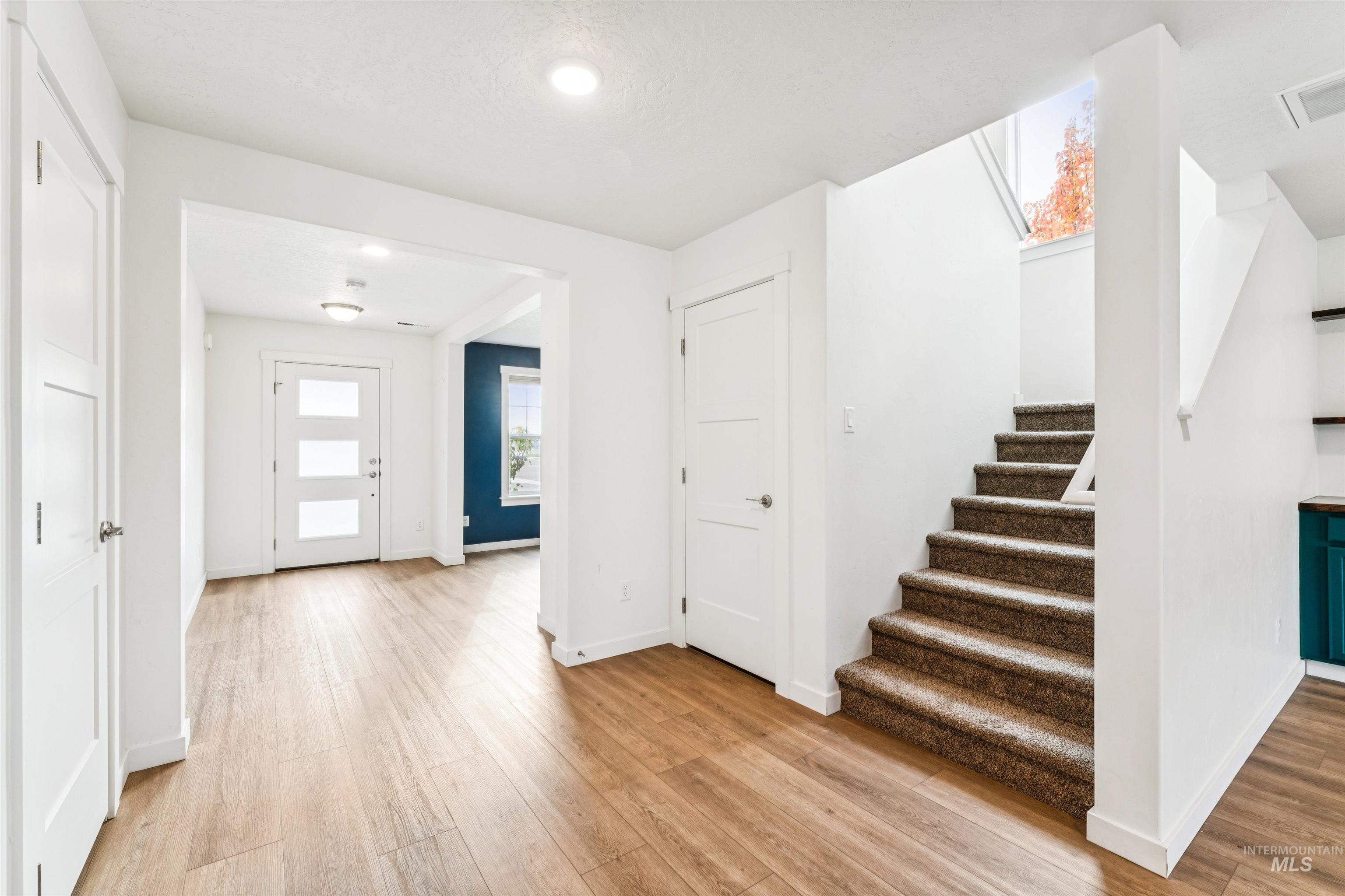 Entryway featuring stairs and light wood finished floors