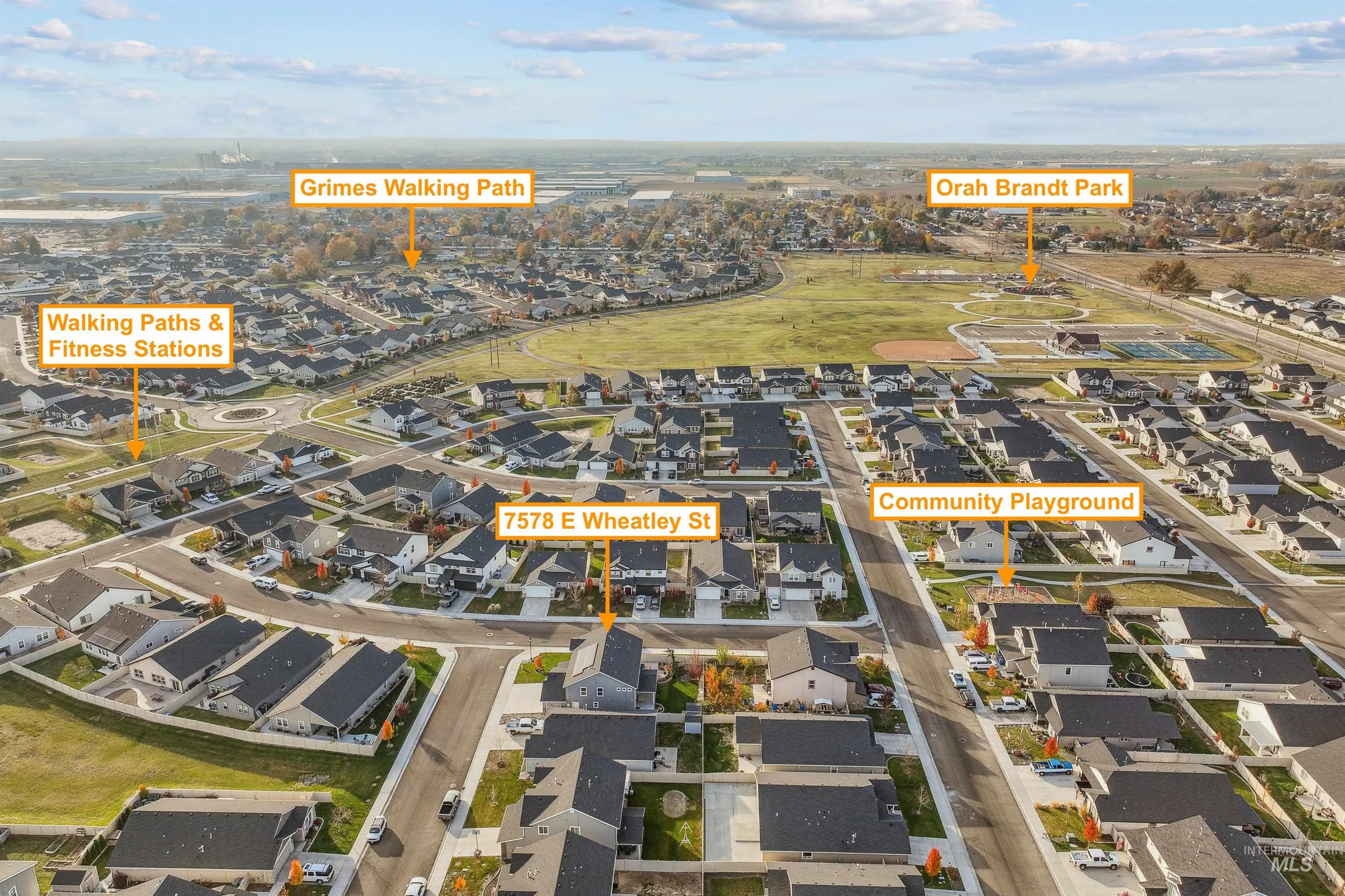 Aerial view of property and surrounding area featuring nearby suburban area