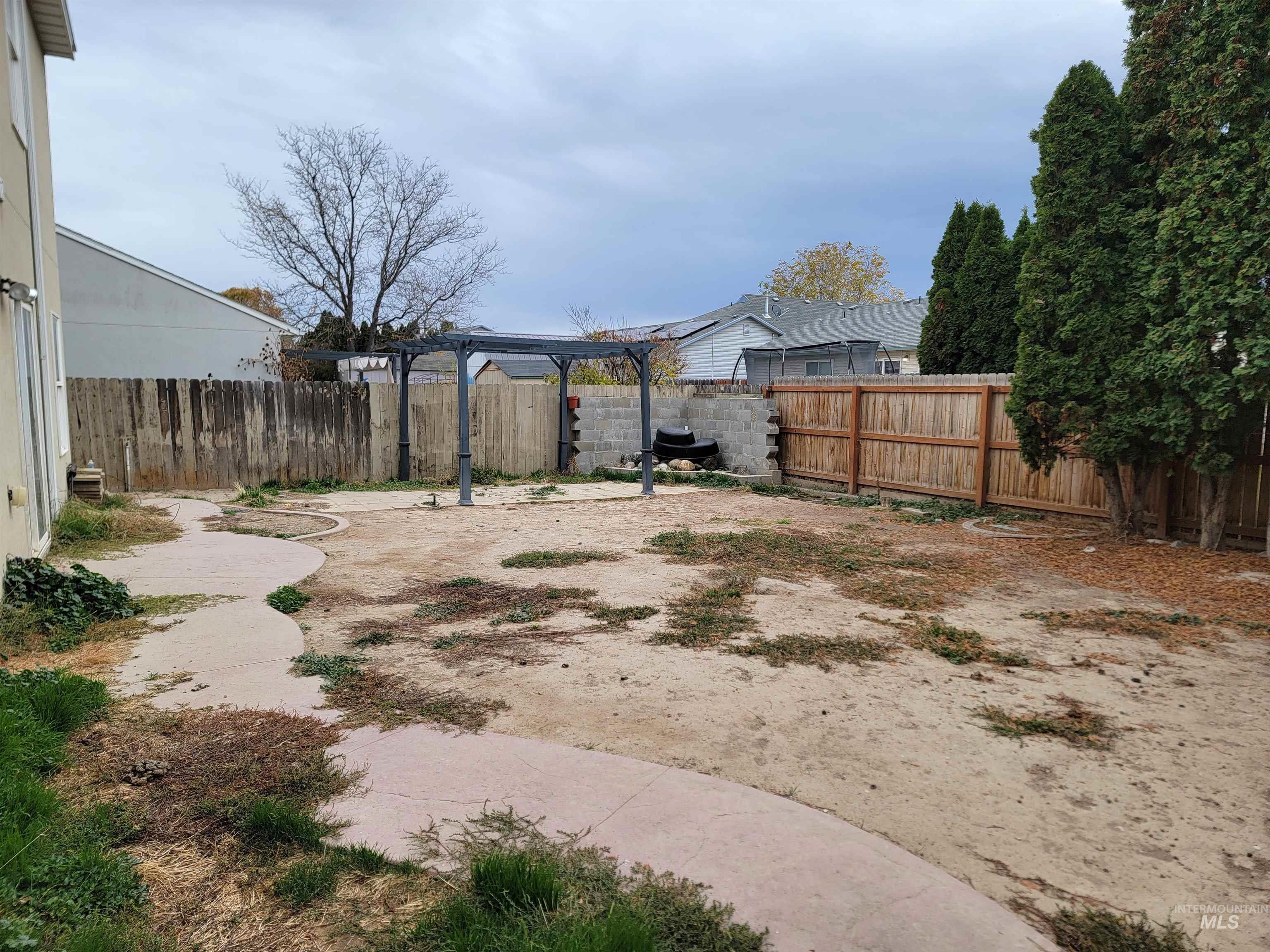 Fenced backyard with a patio and a pergola