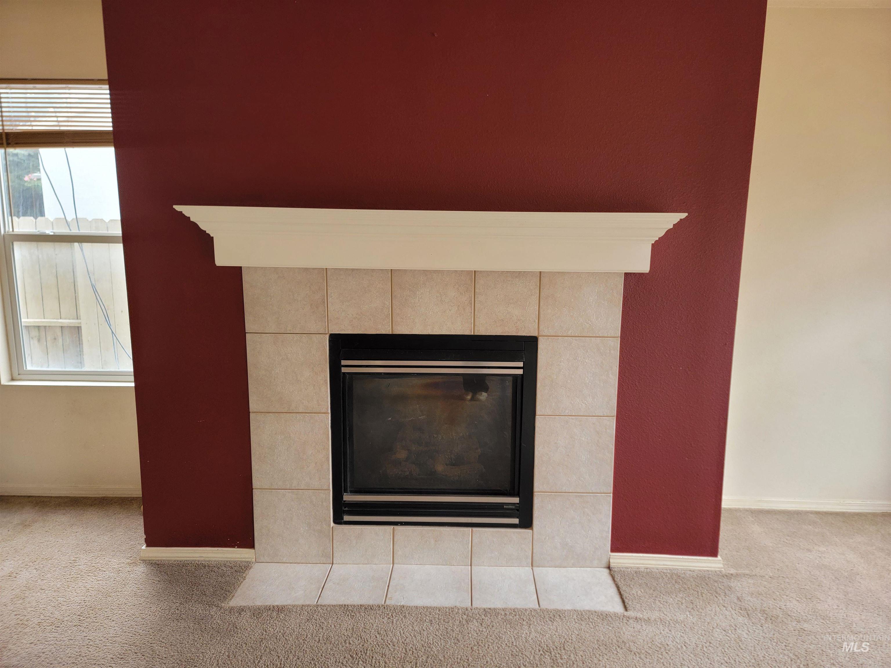 Detailed view of carpet floors and a tile fireplace