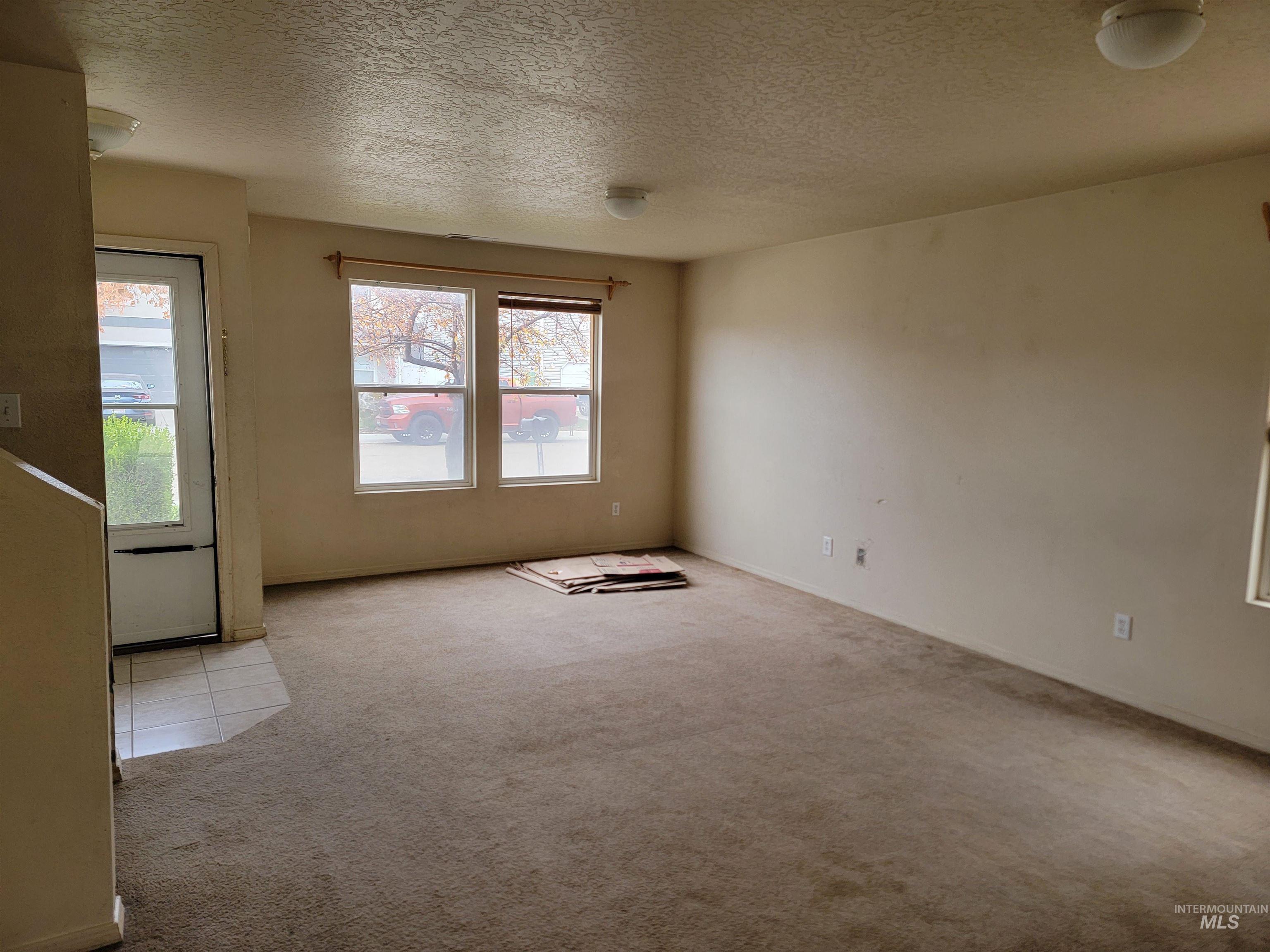 Spare room with carpet flooring and a textured ceiling