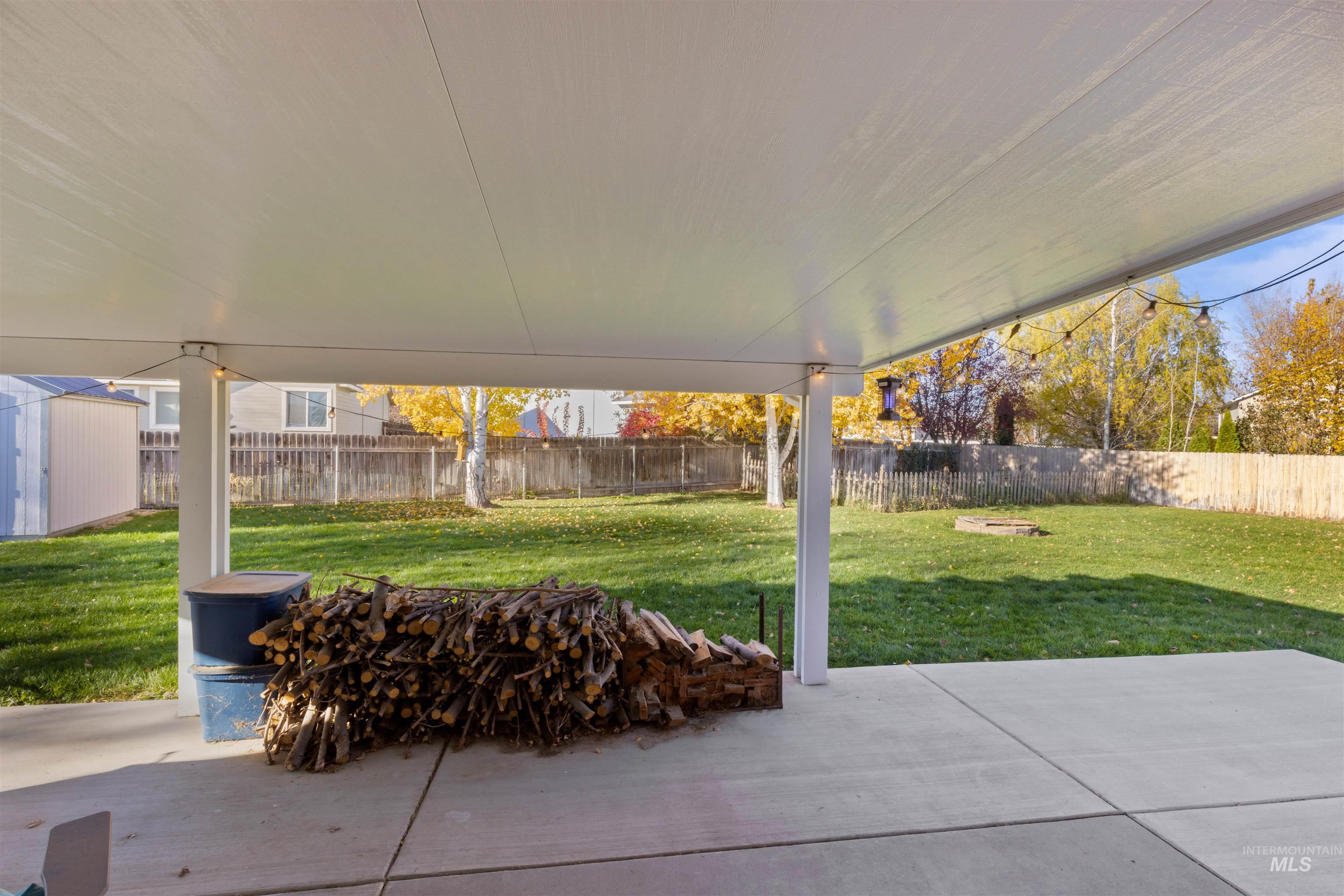 Fenced backyard with a fire pit and a patio