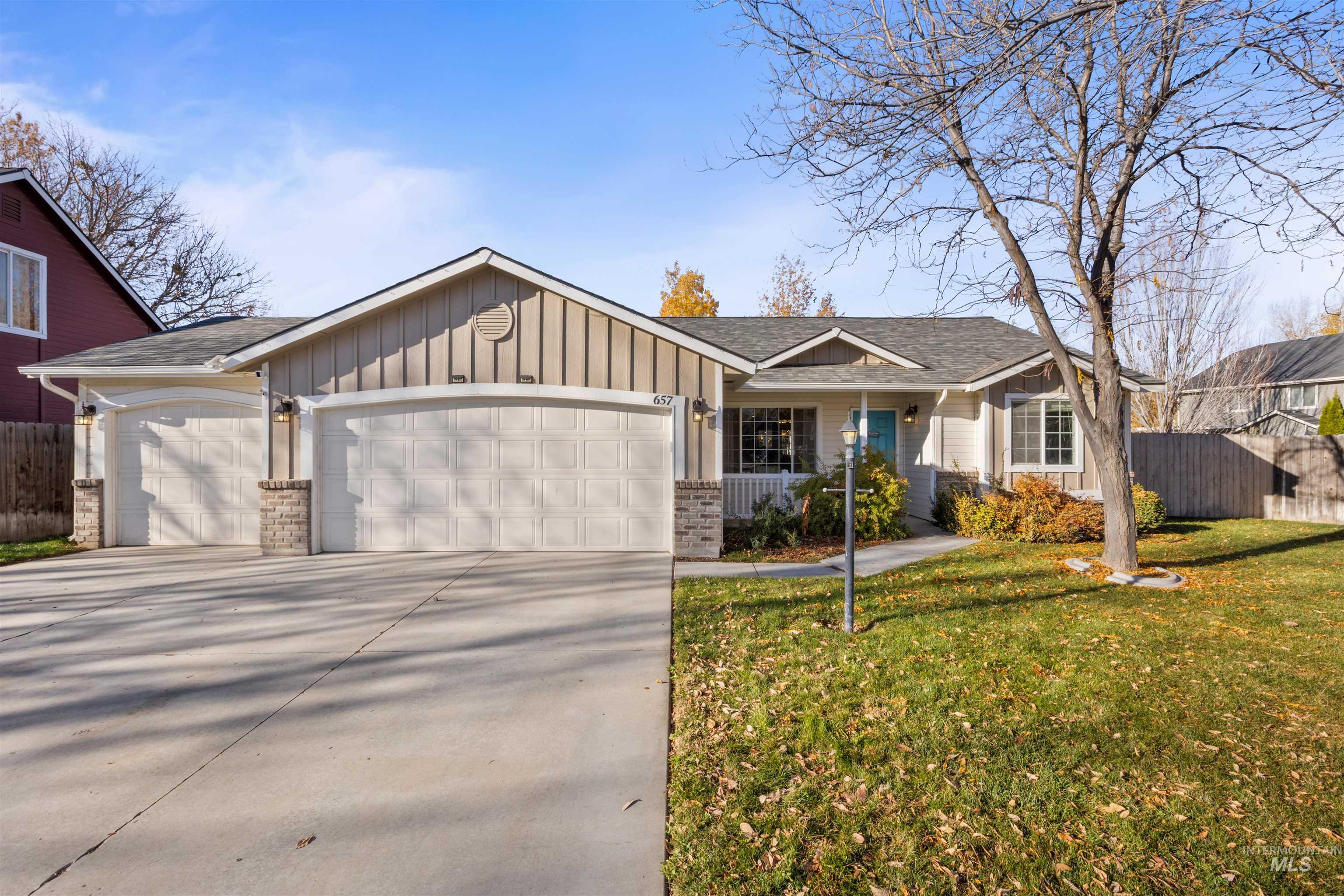 Single story home featuring a garage, board and batten siding, brick siding, driveway, and a porch