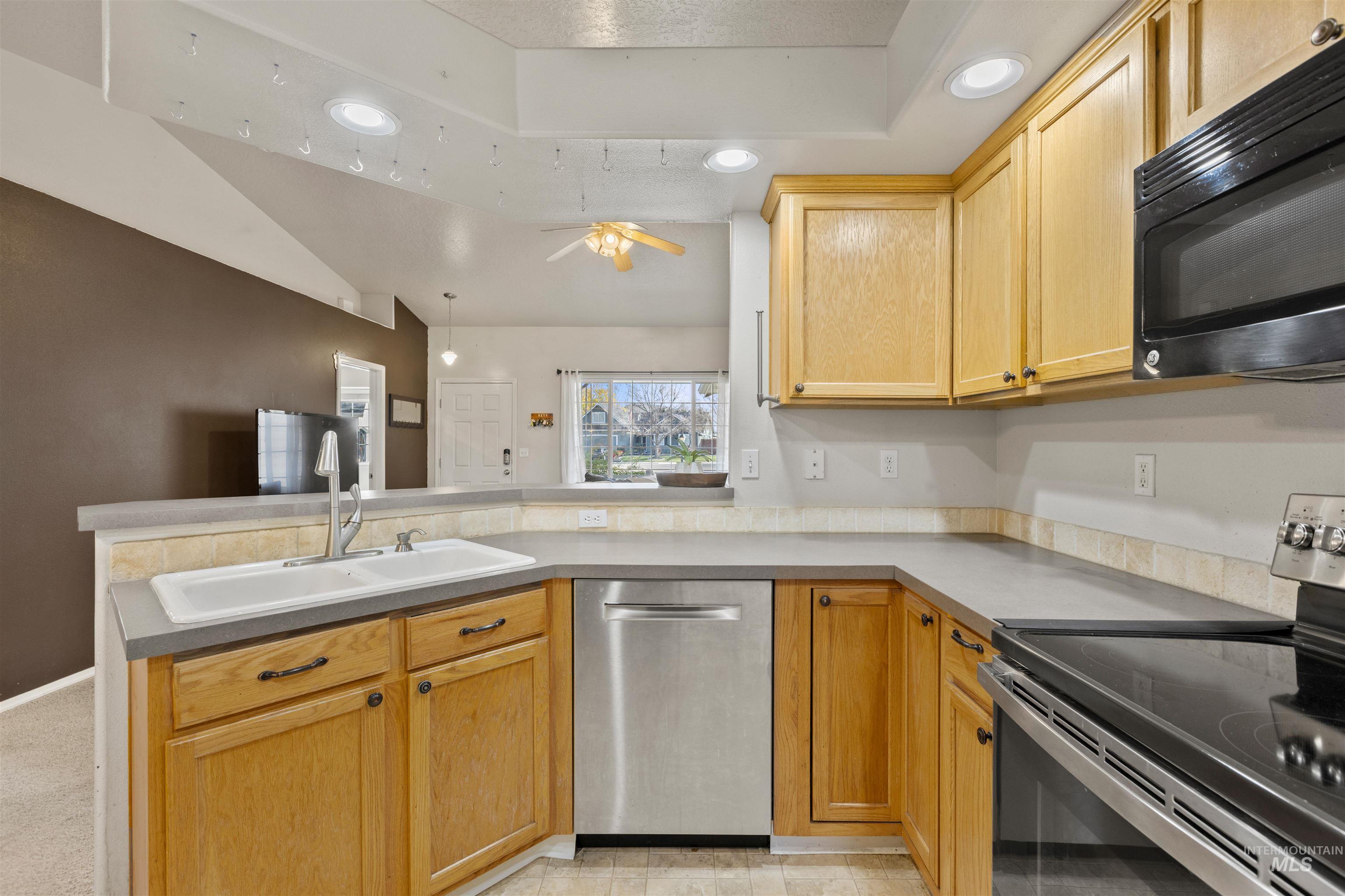 Kitchen featuring stainless steel appliances, recessed lighting, a peninsula, light brown cabinets, and light countertops