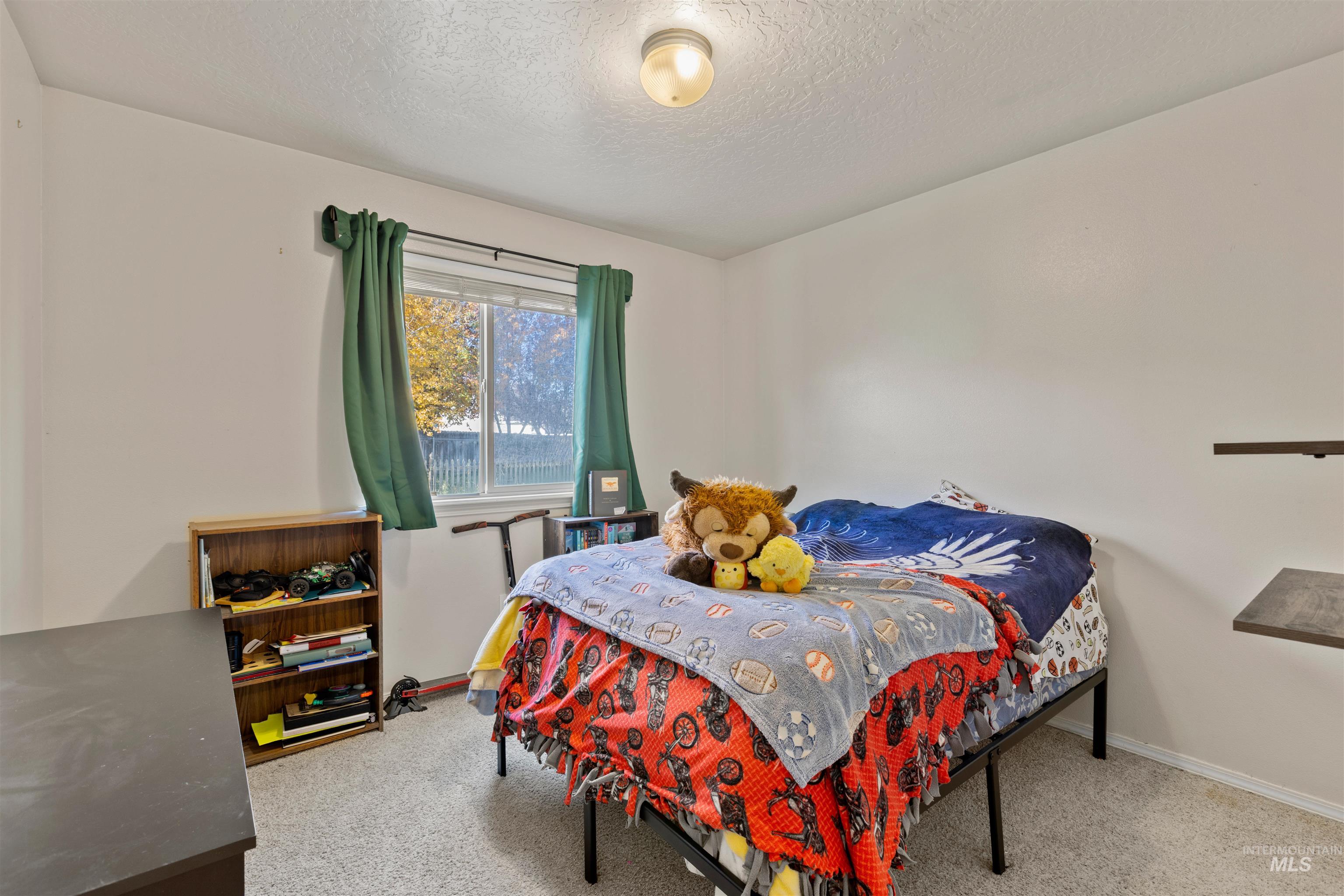 Bedroom featuring light carpet and a textured ceiling