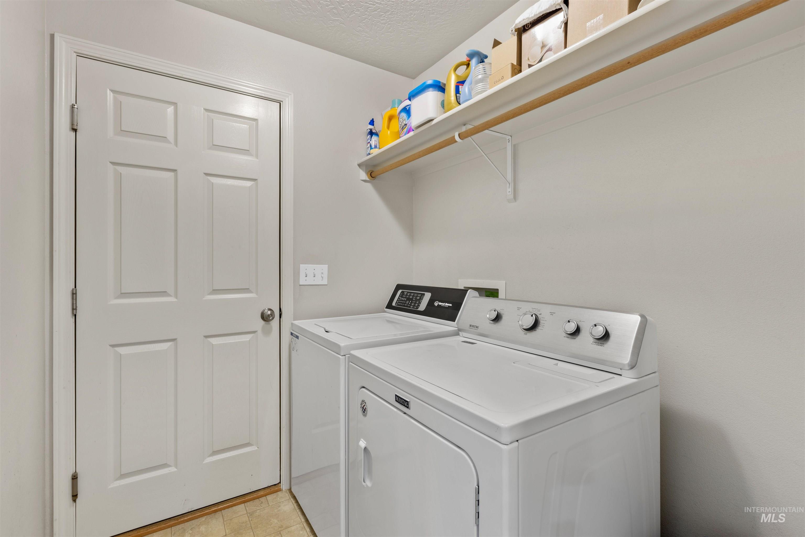 Laundry area featuring separate washer and dryer and a textured ceiling