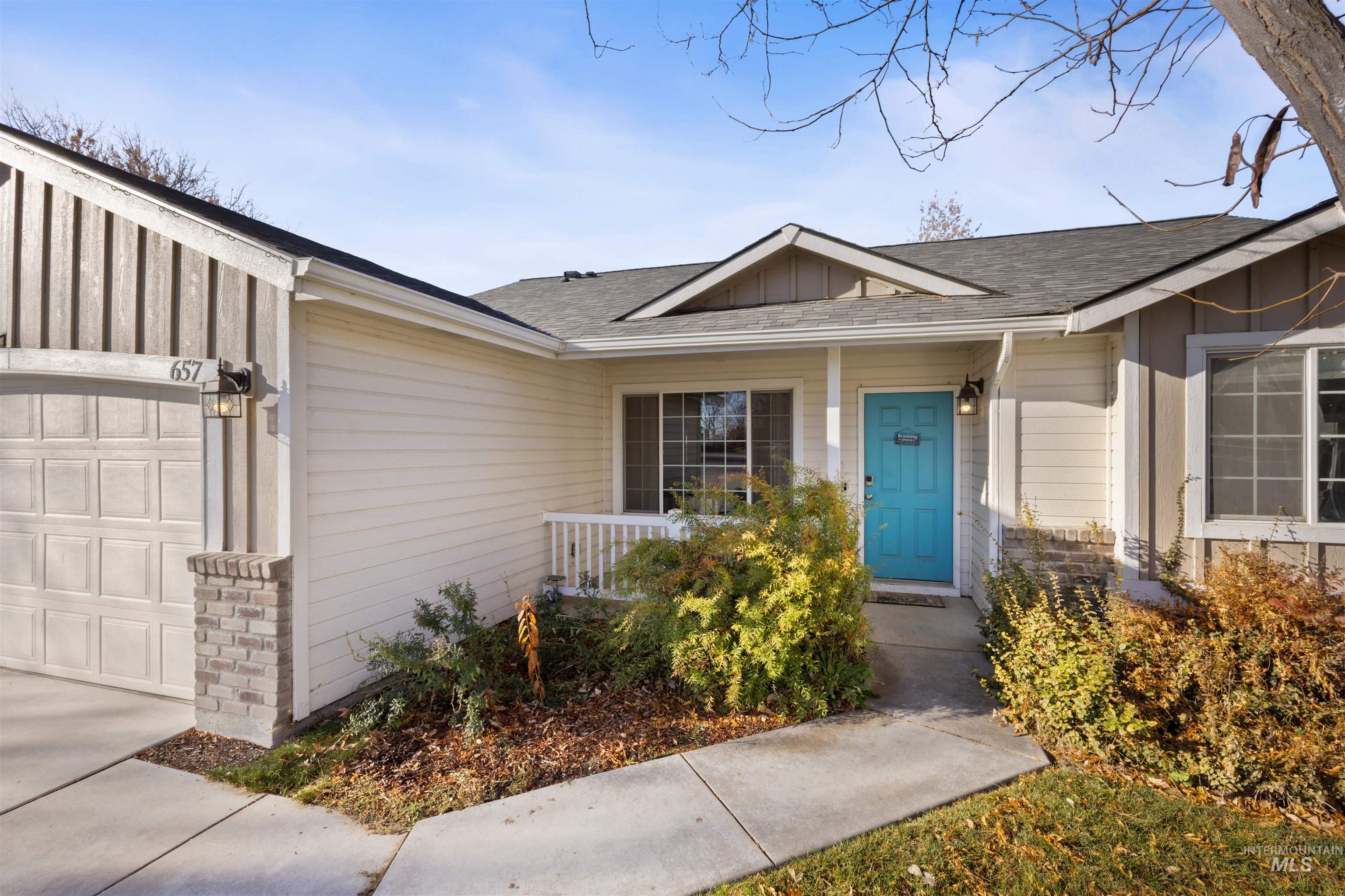 Entrance to property with roof with shingles, a porch, an attached garage, and brick siding