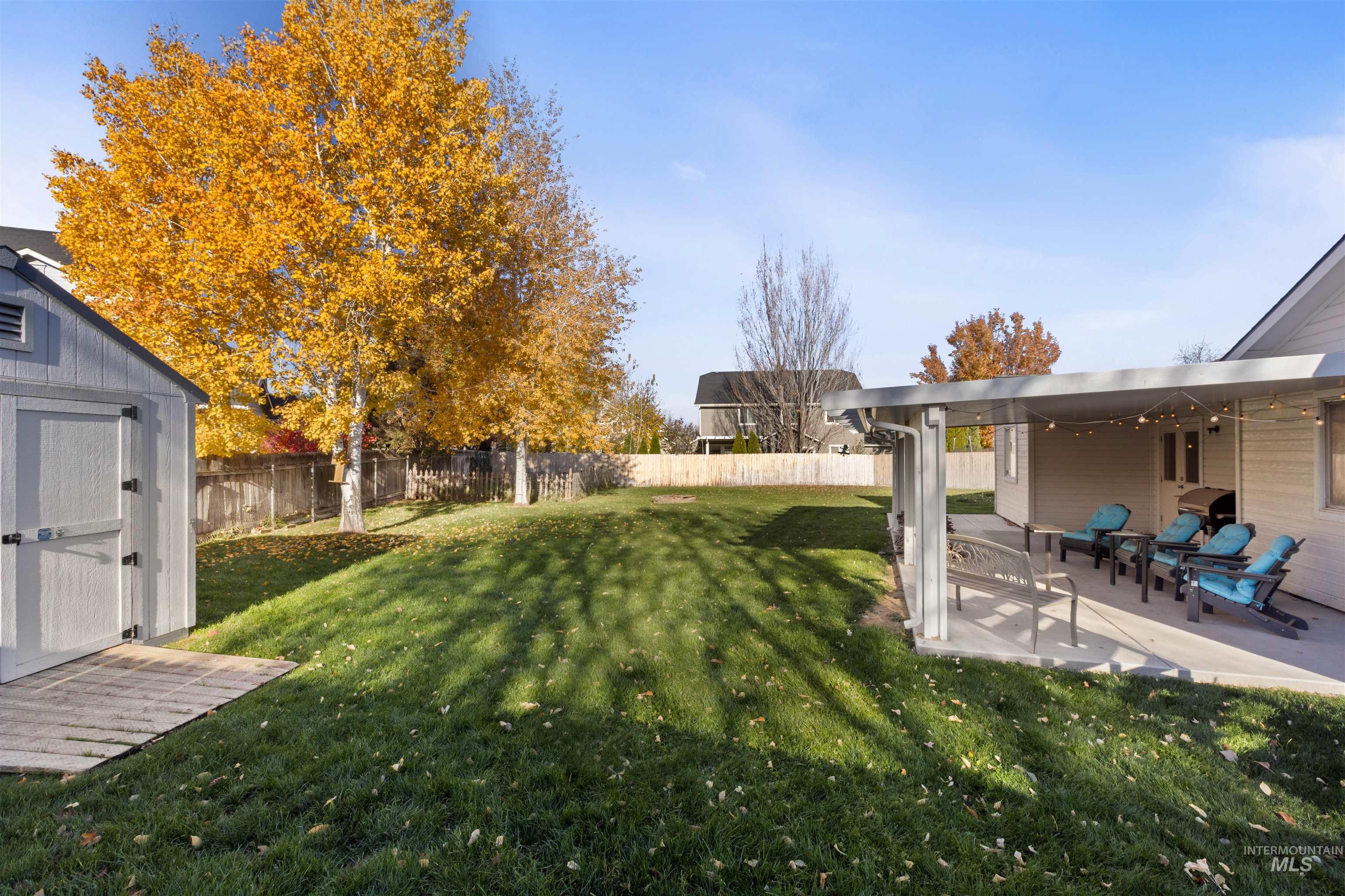 Fenced backyard with a shed and a patio