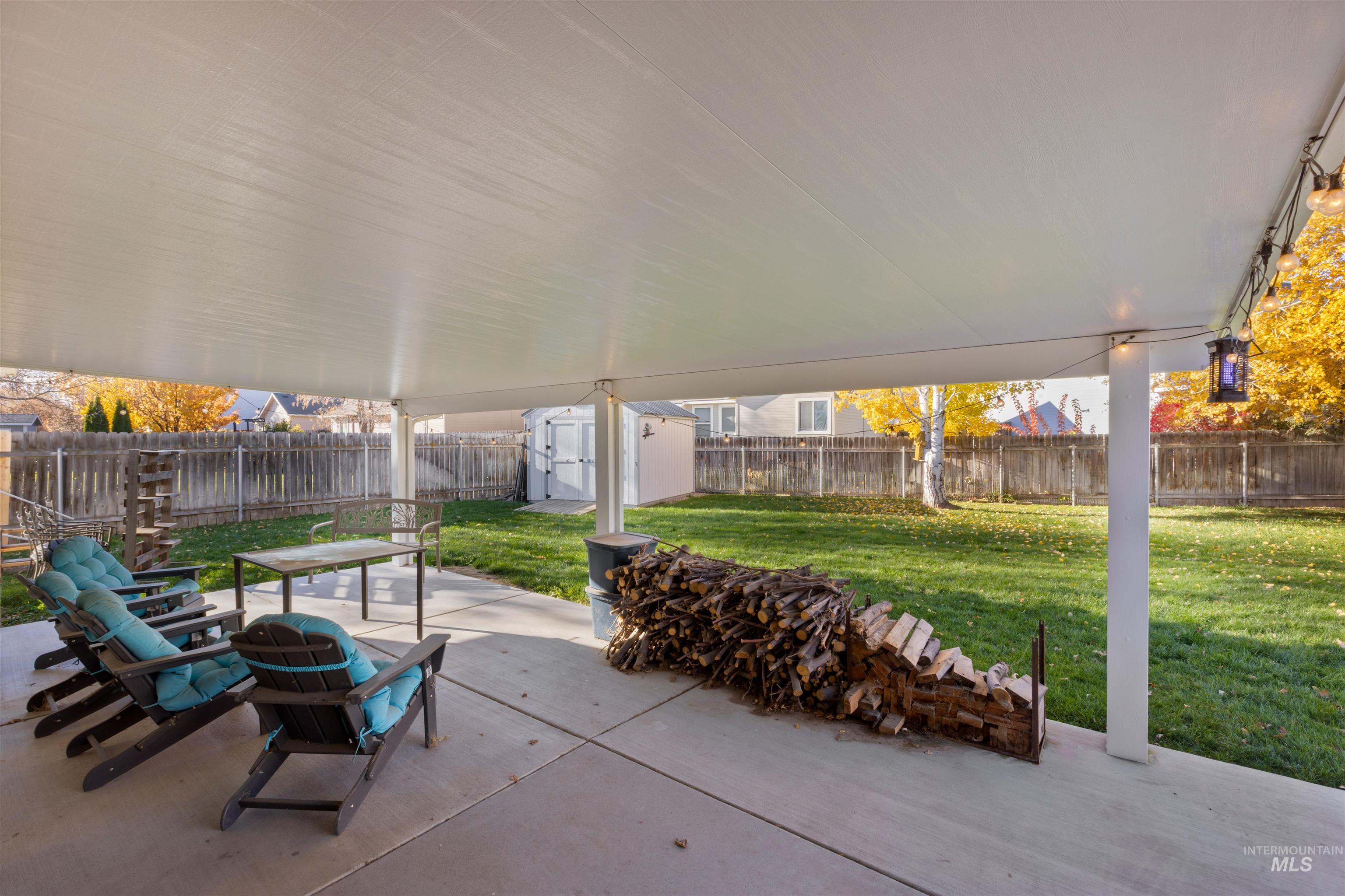 Fenced backyard featuring a shed and a patio
