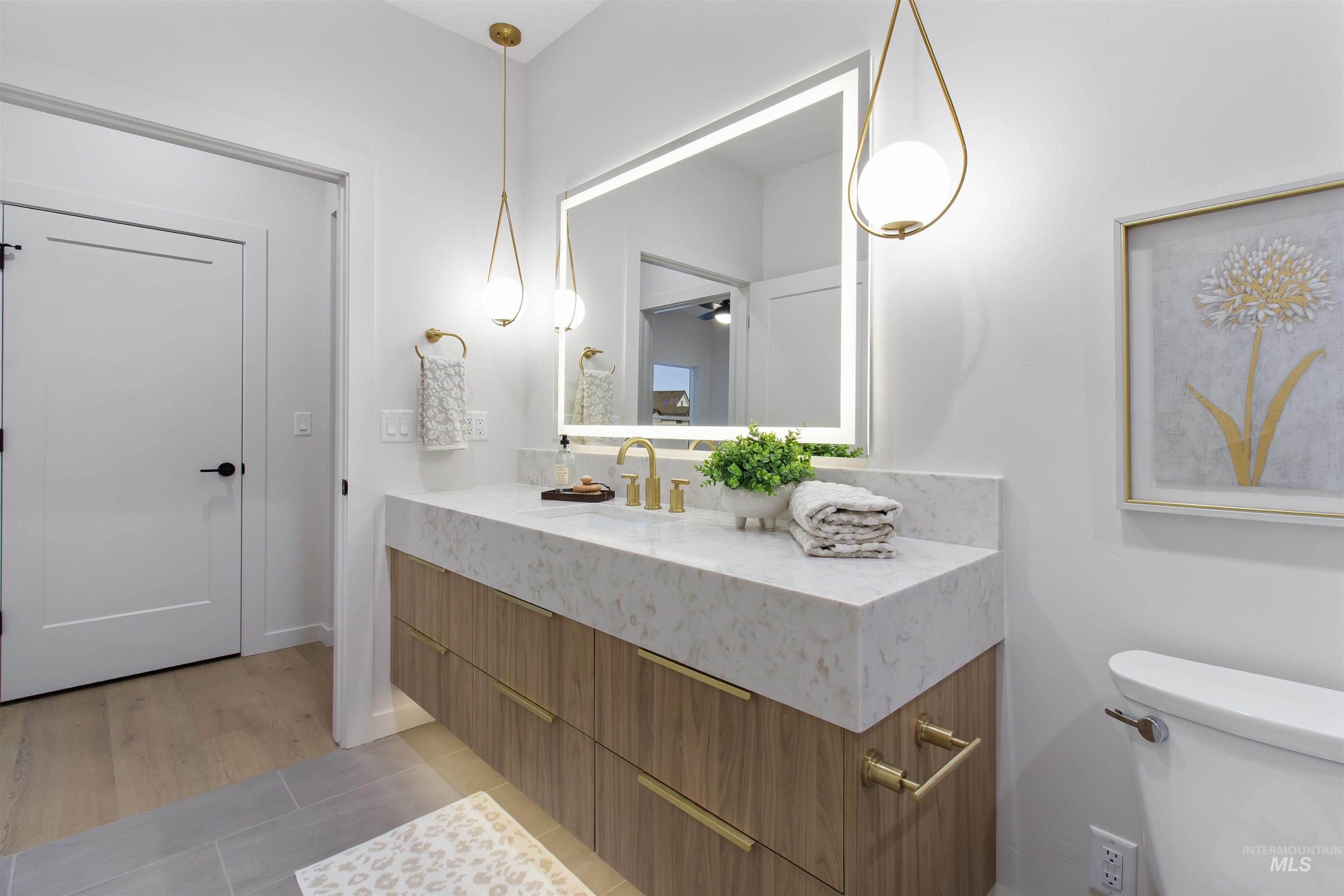 Half bathroom featuring vanity, light tile patterned floors, and a ceiling fan