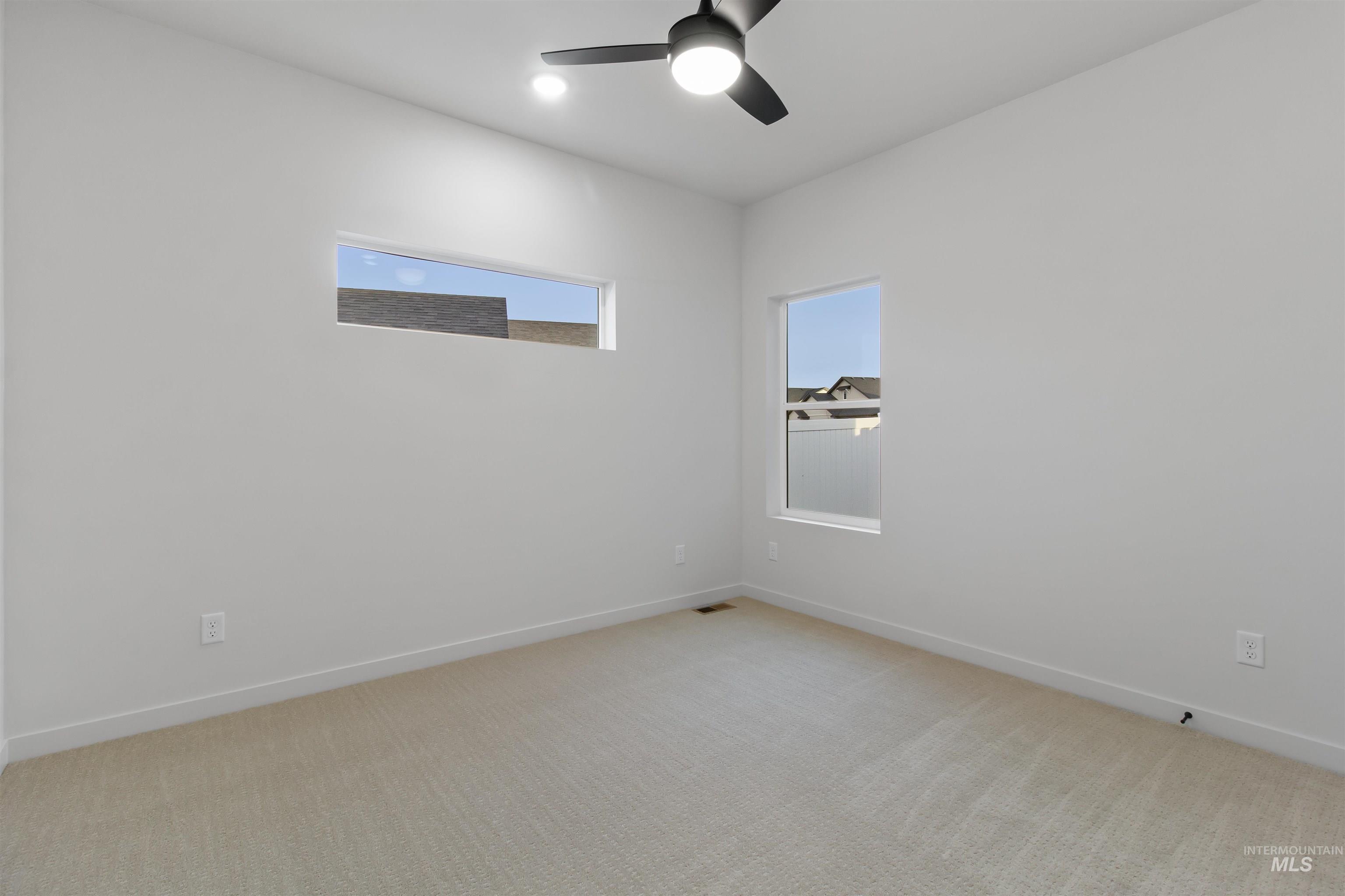 Spare room with light colored carpet and a ceiling fan