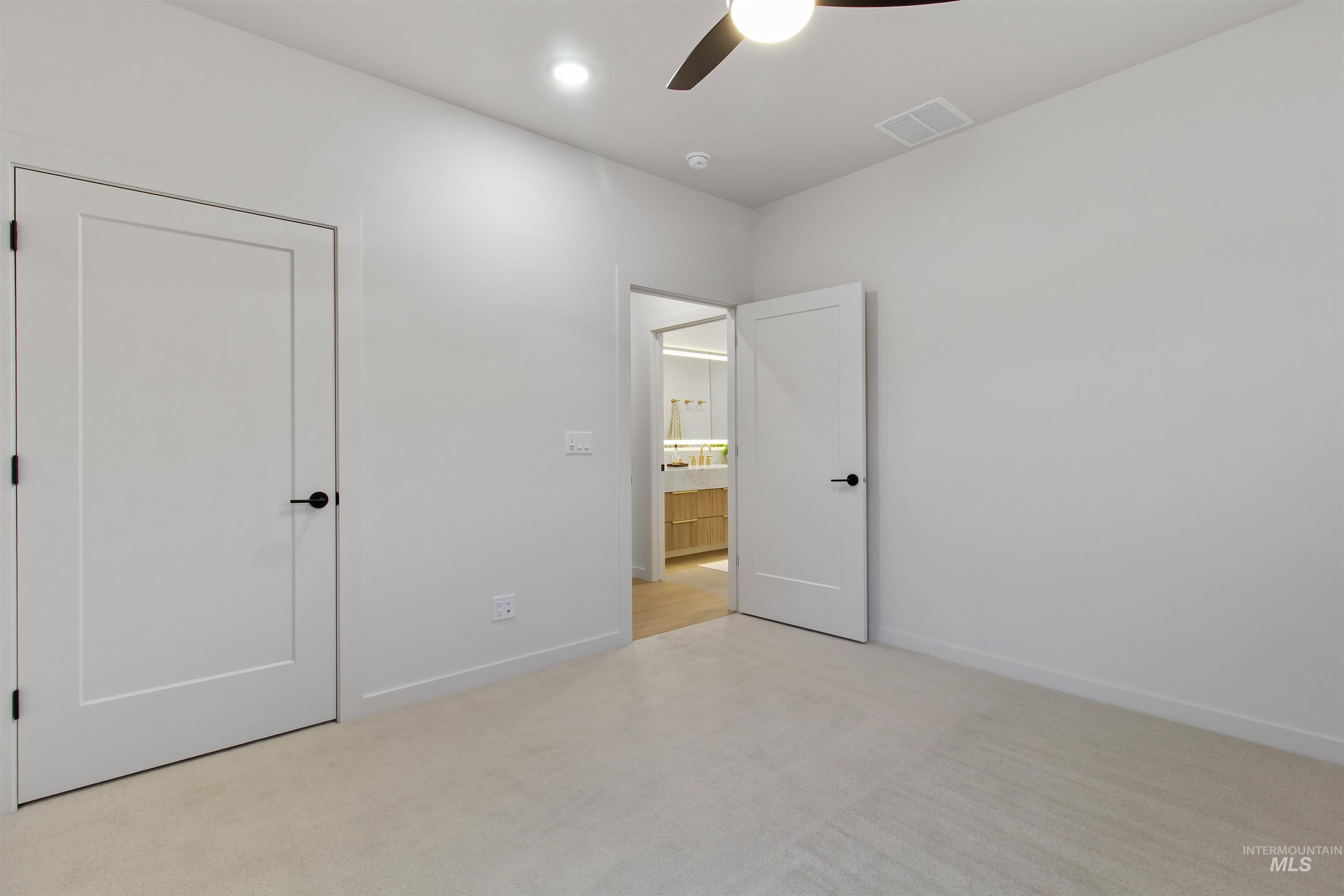 Unfurnished bedroom with light carpet and ceiling fan