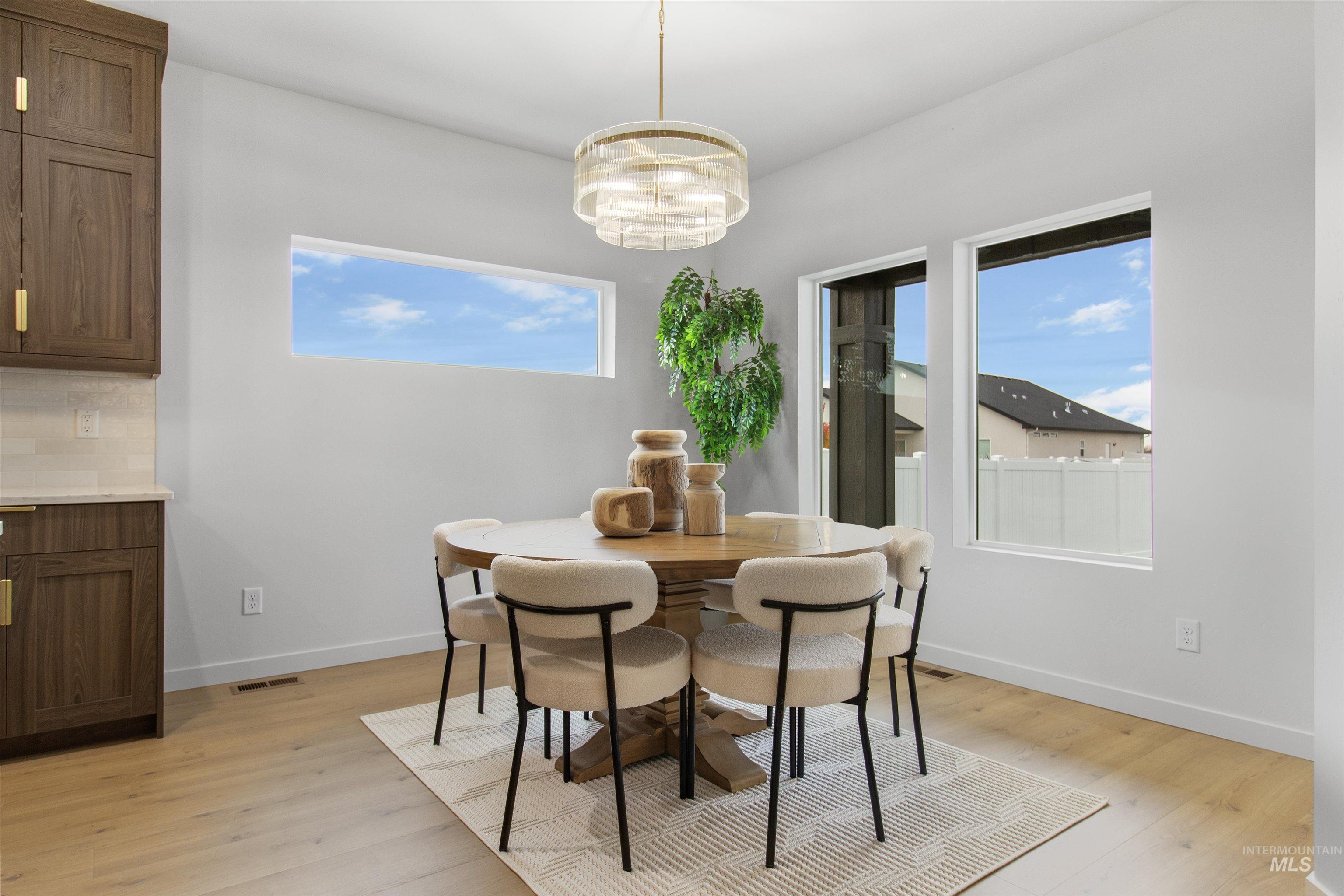 Dining area featuring light wood-type flooring and a chandelier