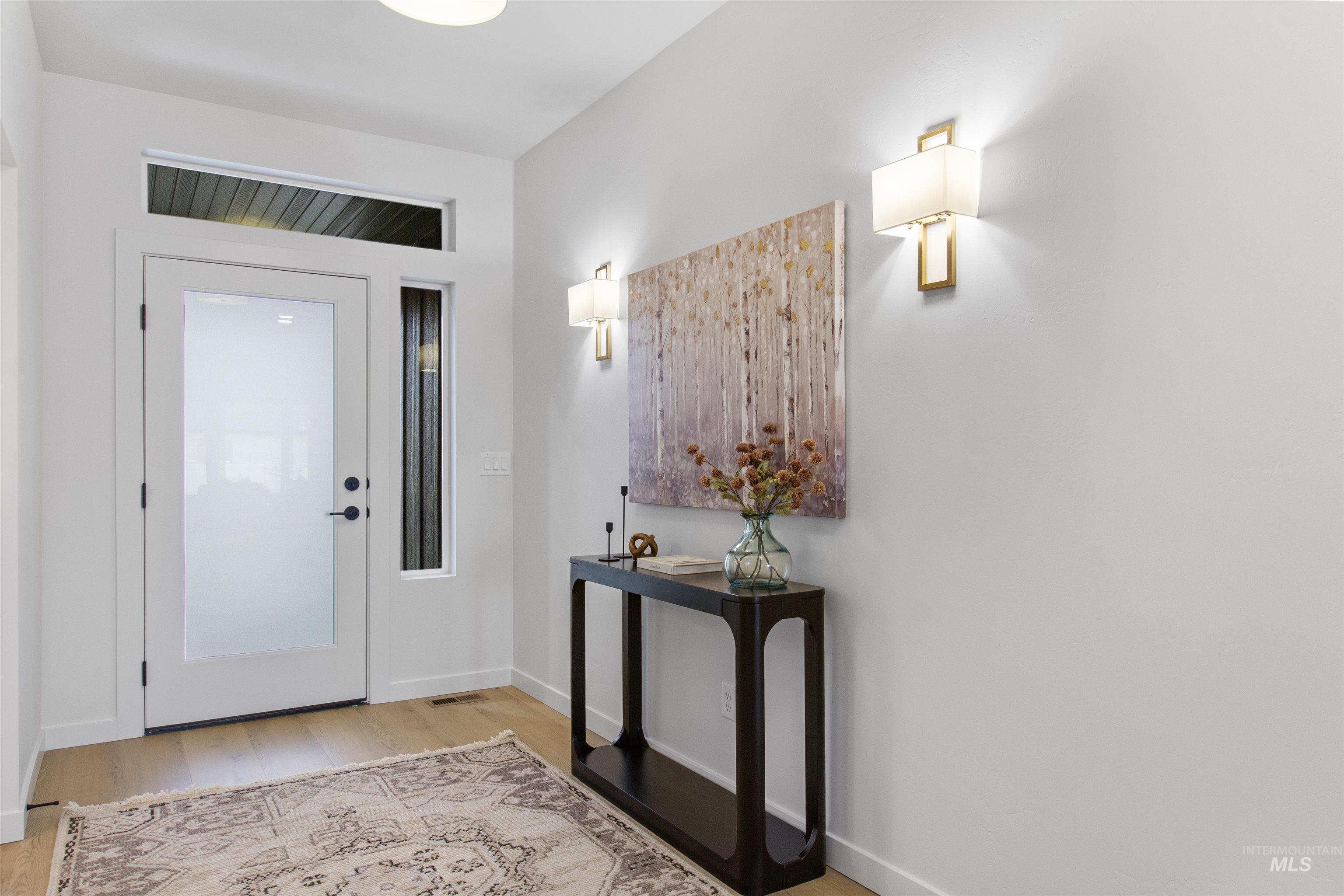 Foyer entrance with light wood-style floors and baseboards