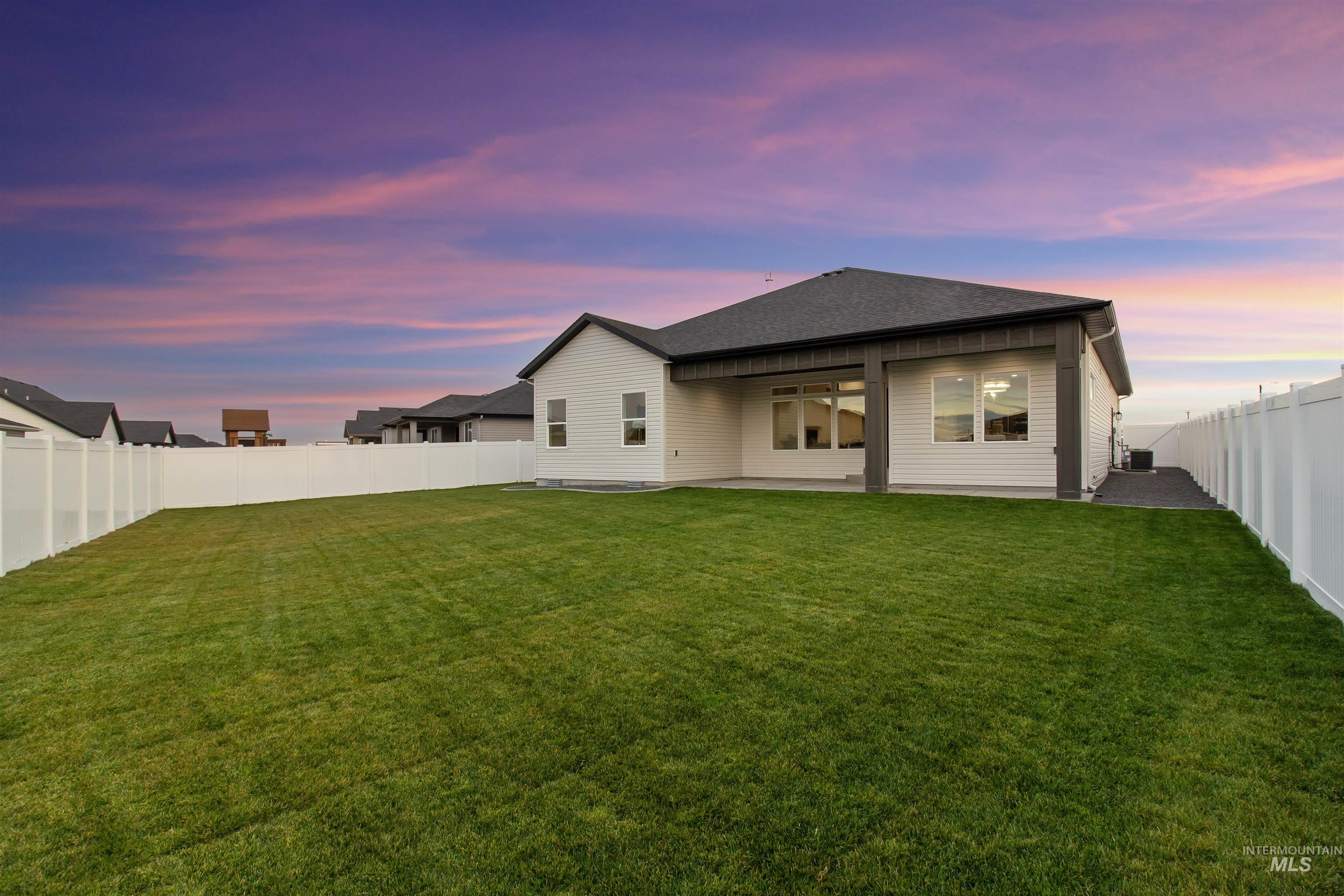 Rear view of property featuring a fenced backyard, a patio, ceiling fan, and roof with shingles