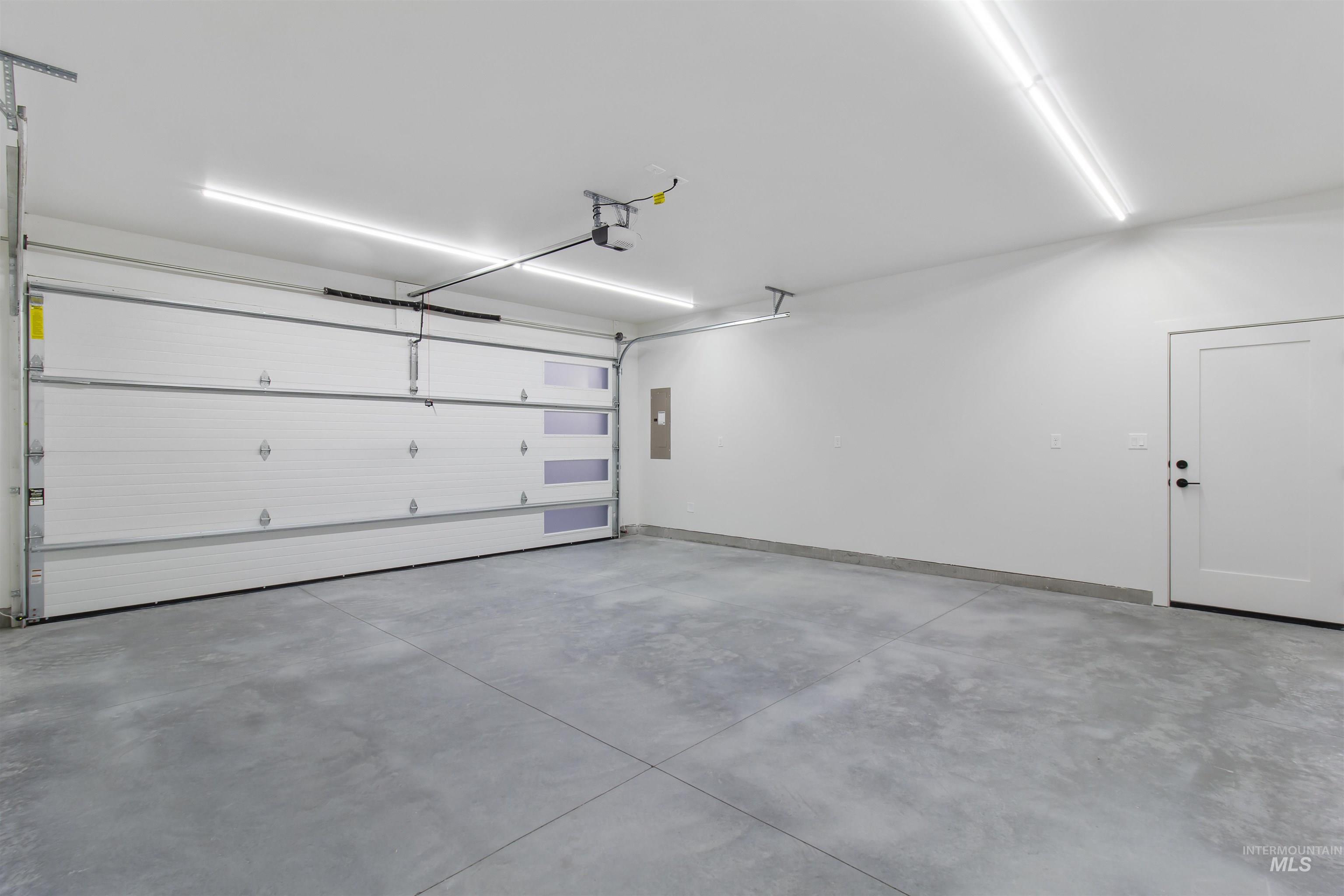 Garage with electric panel and baseboards