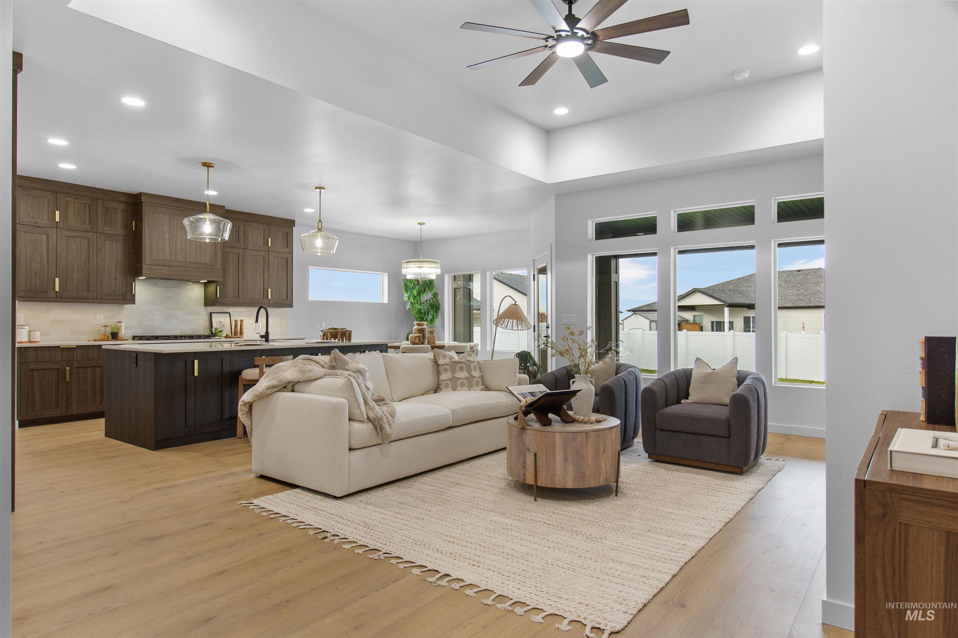 Living room with light wood-style floors, recessed lighting, and ceiling fan