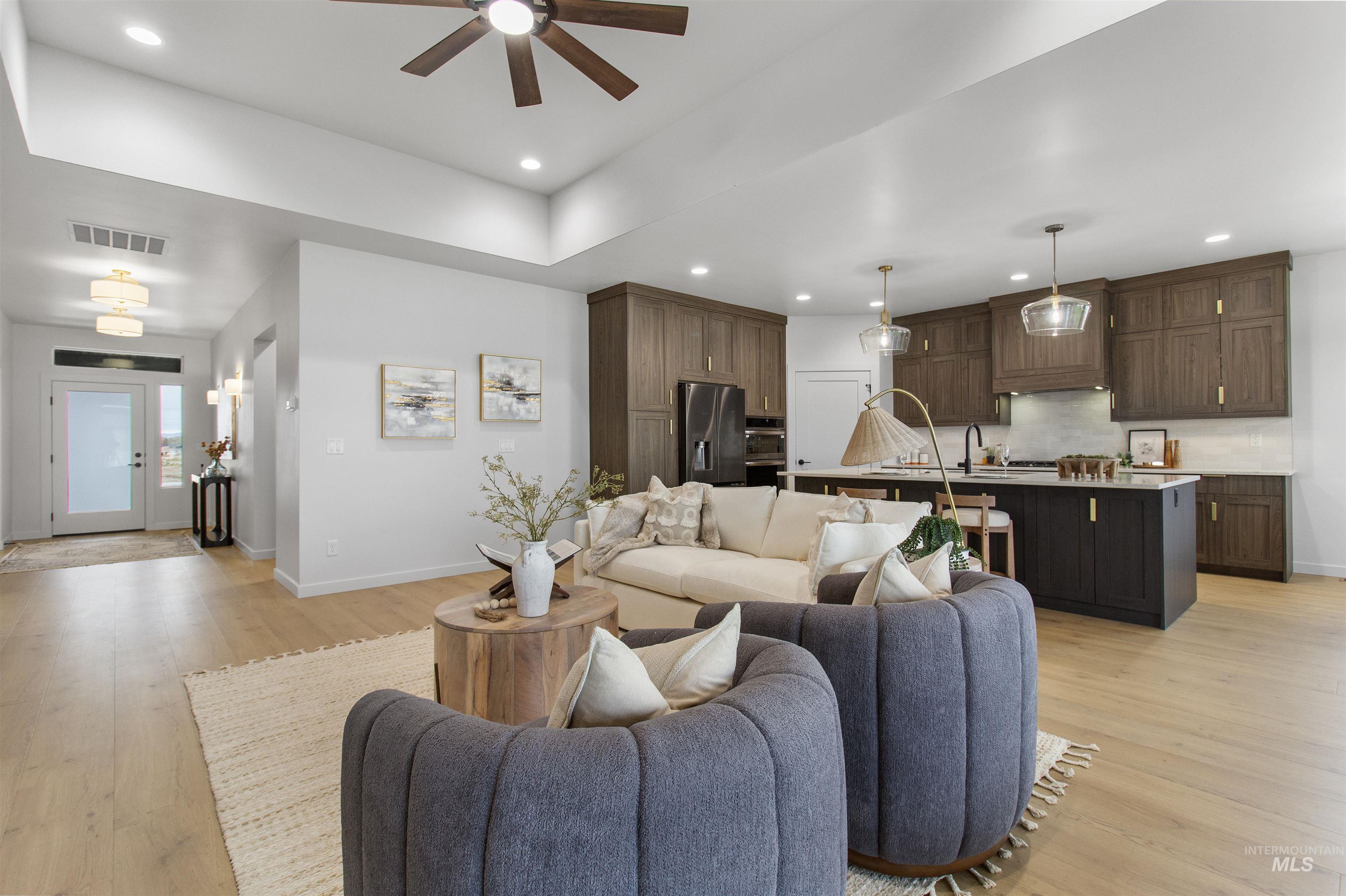 Living room featuring light wood-style flooring, recessed lighting, and a ceiling fan