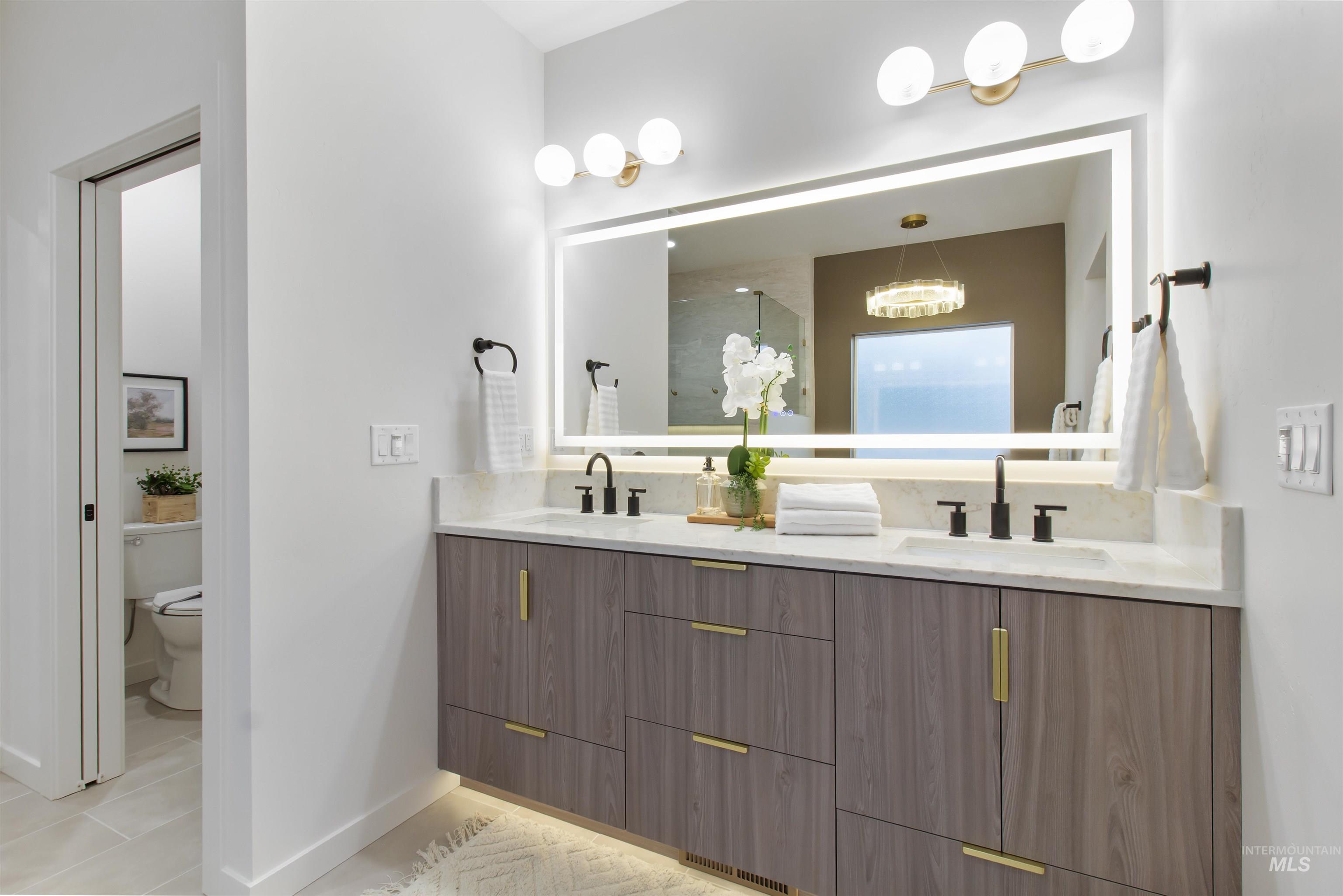 Full bathroom featuring double vanity, light tile patterned floors, and walk in shower