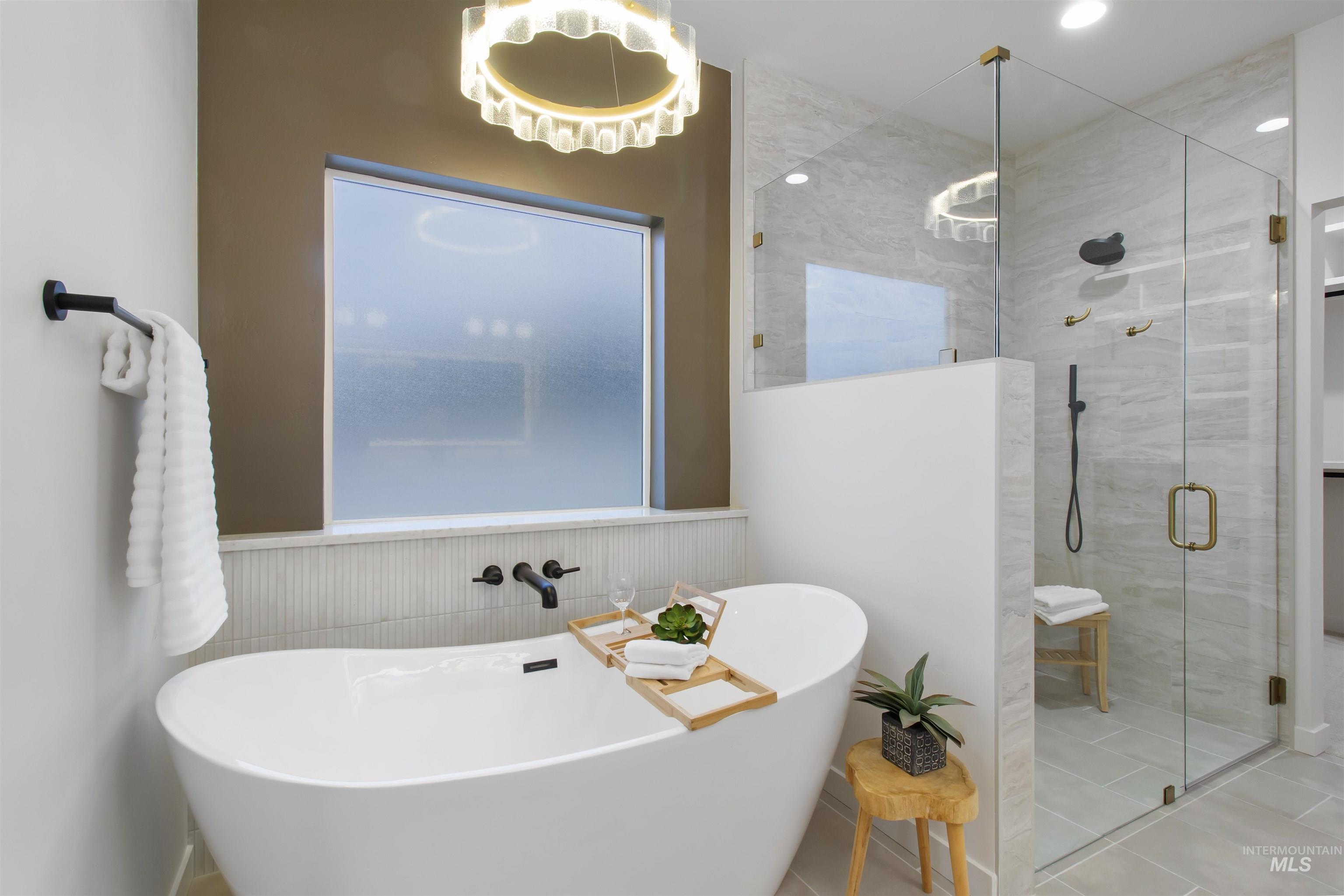 Bathroom with a freestanding tub, wainscoting, a shower stall, tile patterned floors, and recessed lighting
