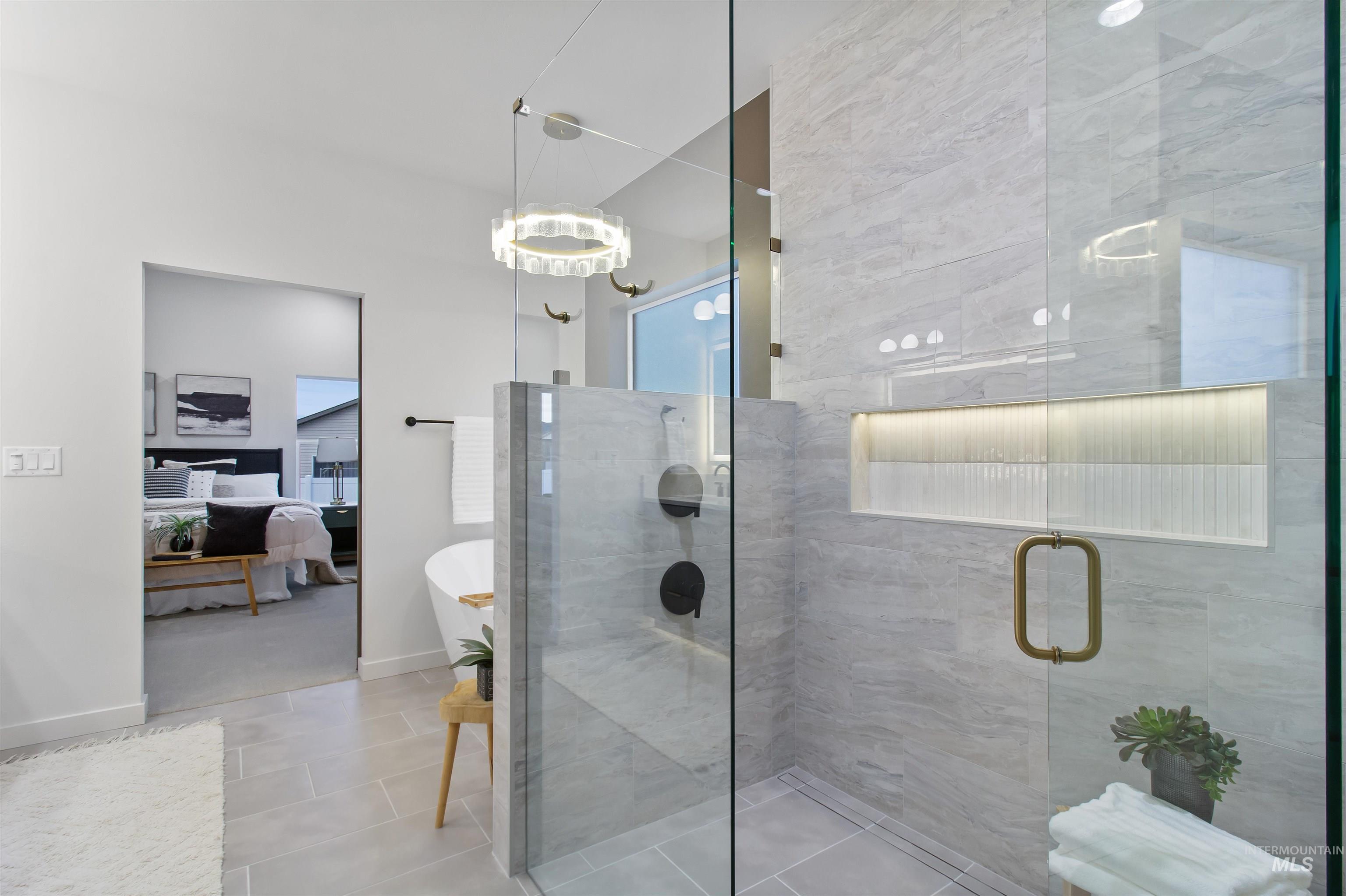 Ensuite bathroom featuring a stall shower, a freestanding tub, tile patterned floors, and plenty of natural light