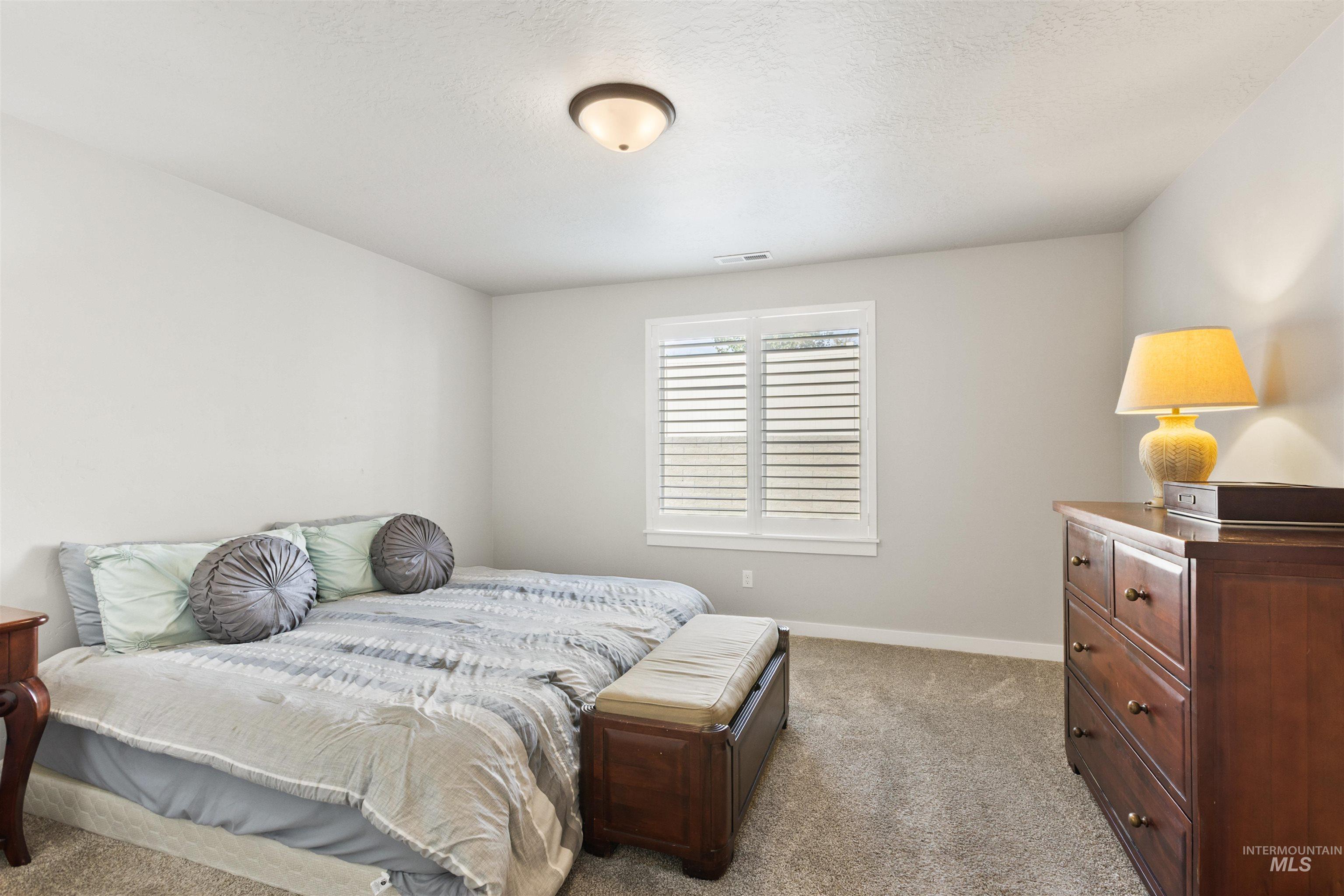 Bedroom with light carpet and a textured ceiling