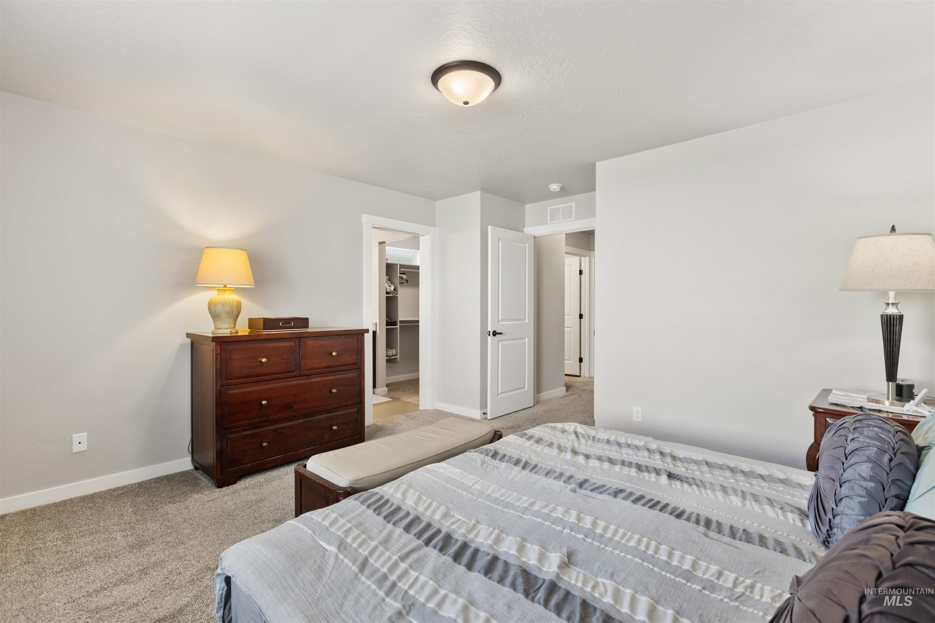 Bedroom with light carpet and a spacious closet