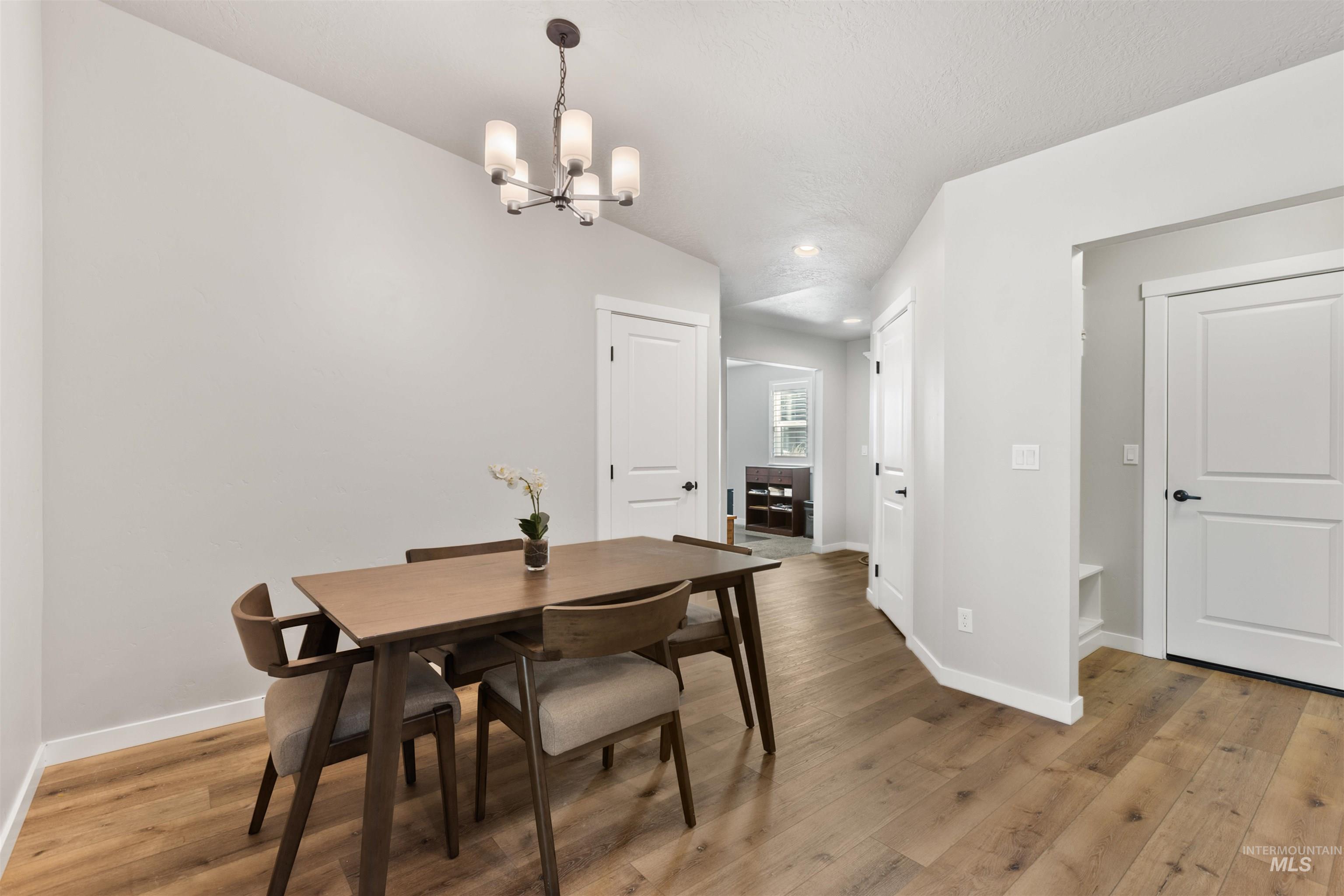 Dining room with light wood-style flooring, a chandelier, and recessed lighting