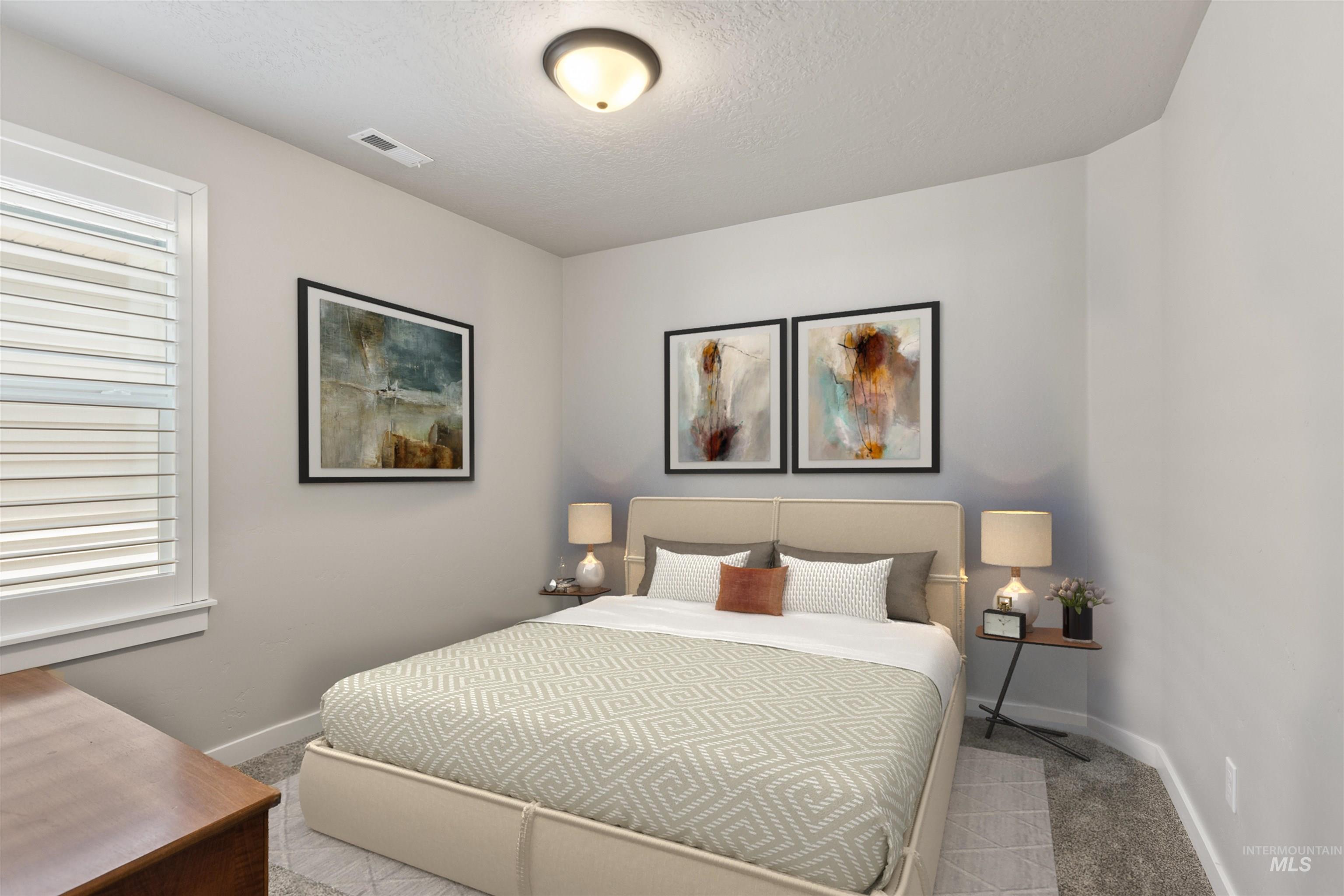 Bedroom featuring light colored carpet and a textured ceiling