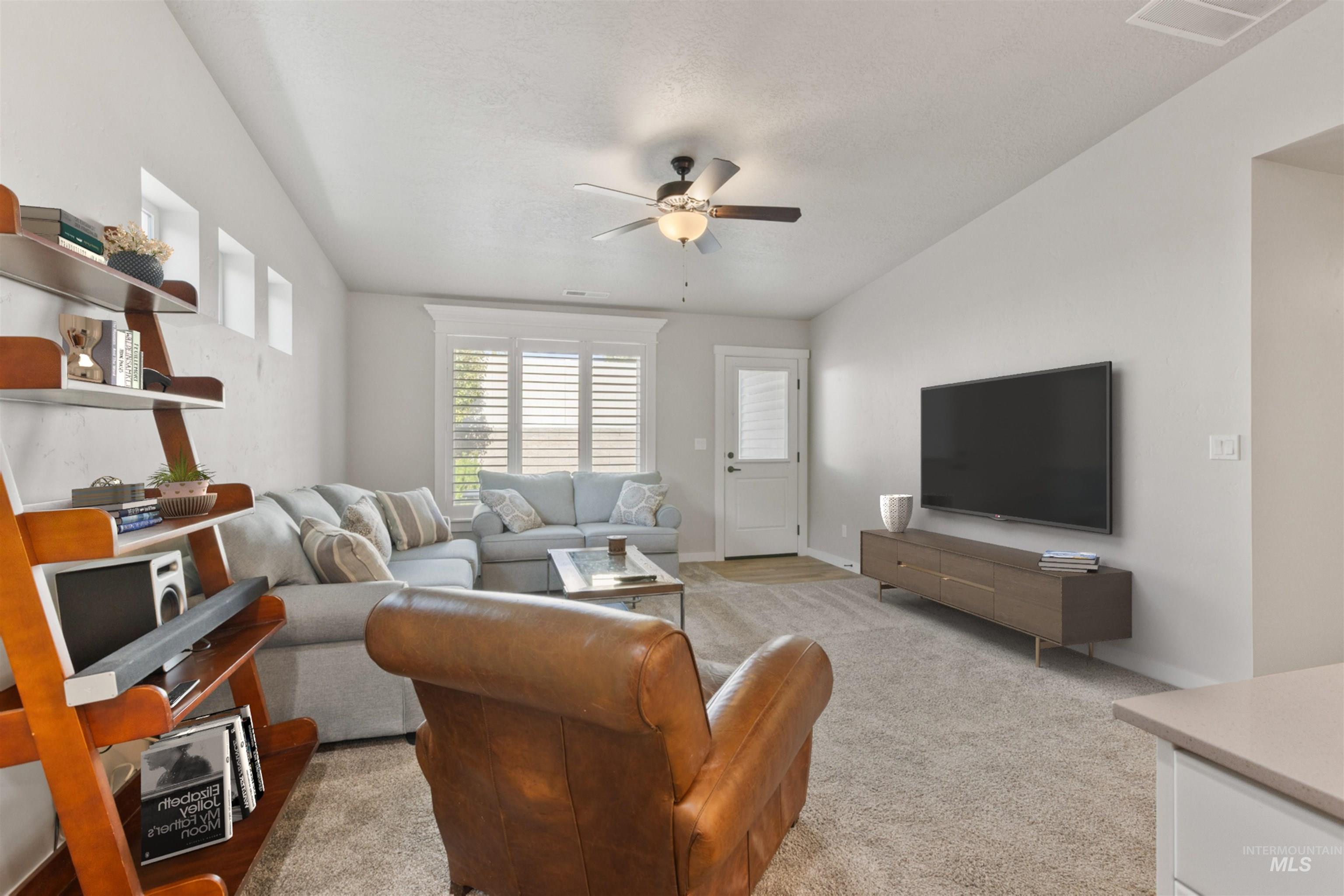 Living area featuring ceiling fan and light colored carpet