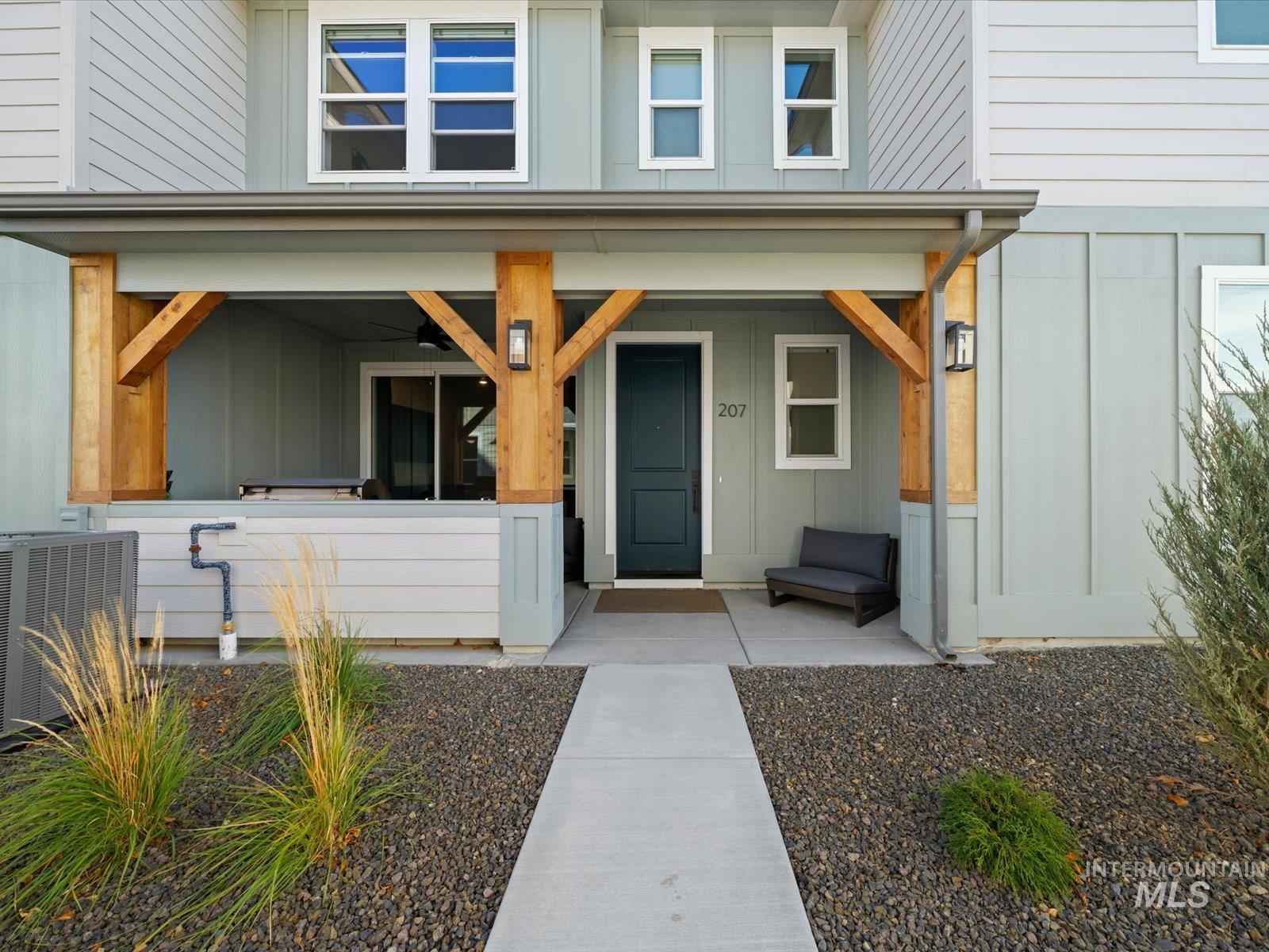 View of exterior entry with board and batten siding and covered porch