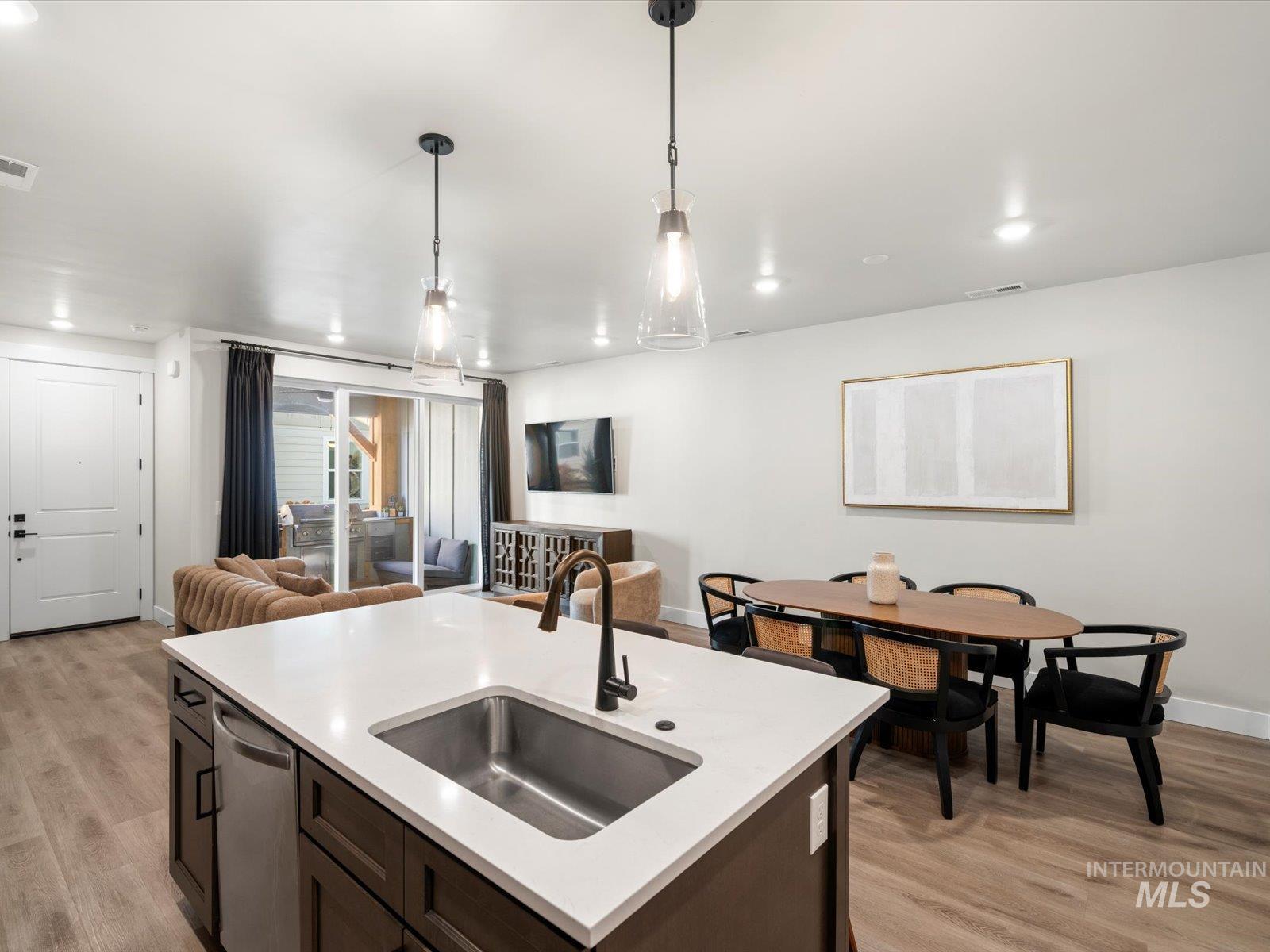 Kitchen with dark brown cabinets, open floor plan, light wood-style floors, and recessed lighting