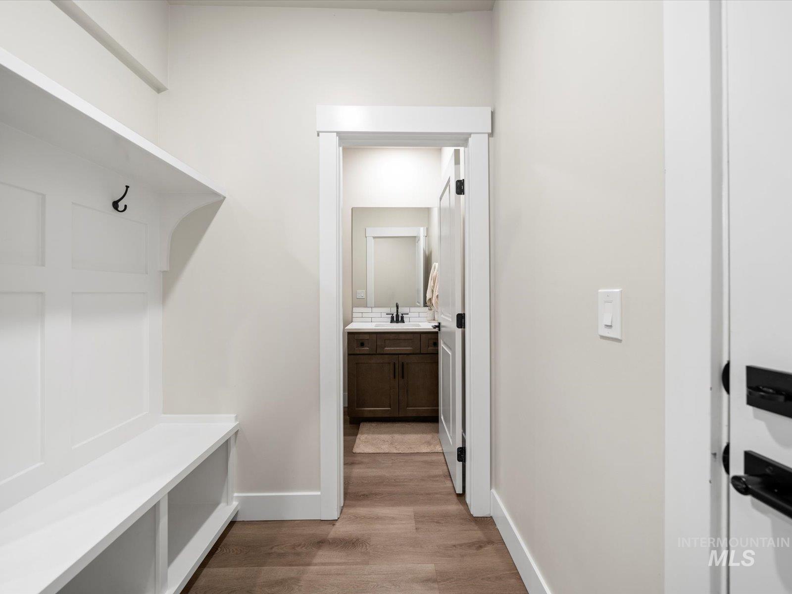 Mudroom featuring light wood finished floors and baseboards