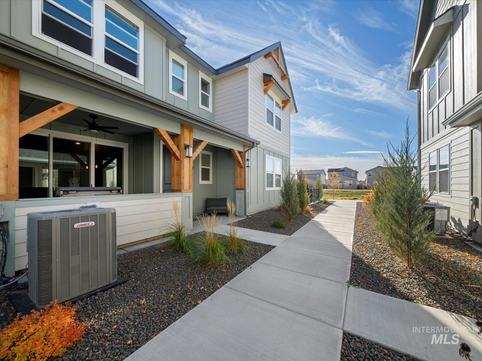 View of property exterior with board and batten siding, a residential view, and a ceiling fan