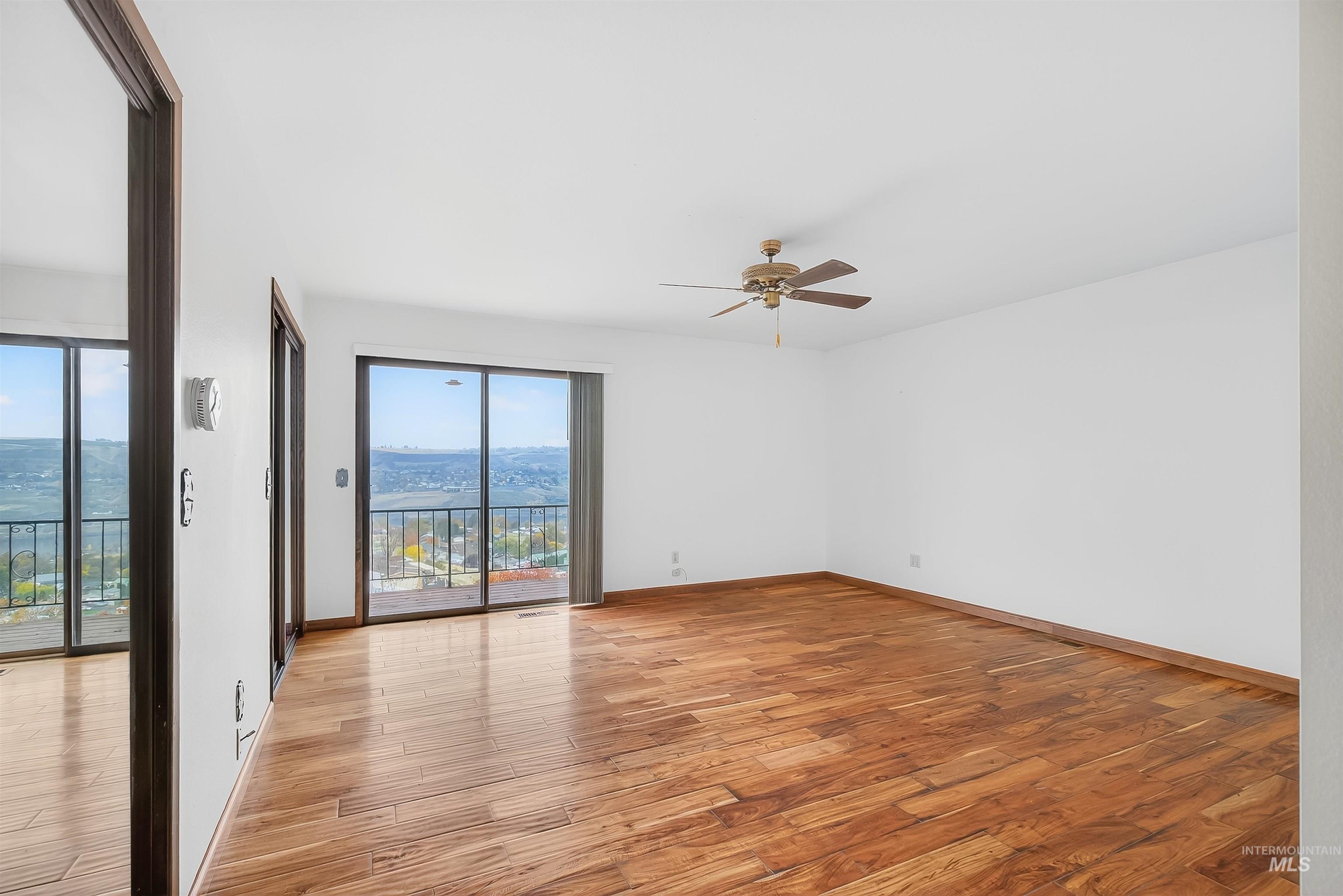 Unfurnished room featuring light wood-type flooring and ceiling fan