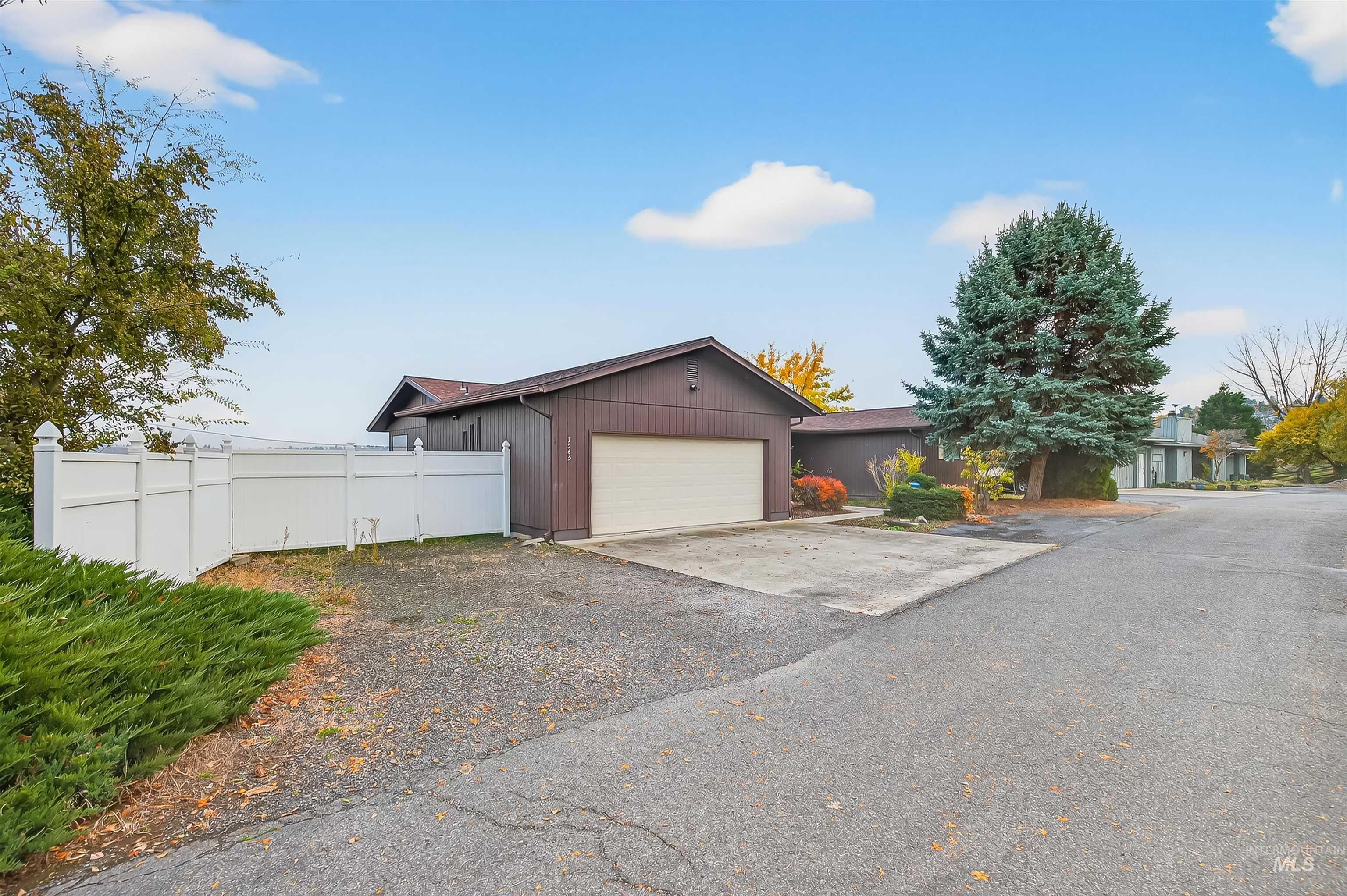 View of front of property with concrete driveway and an attached garage