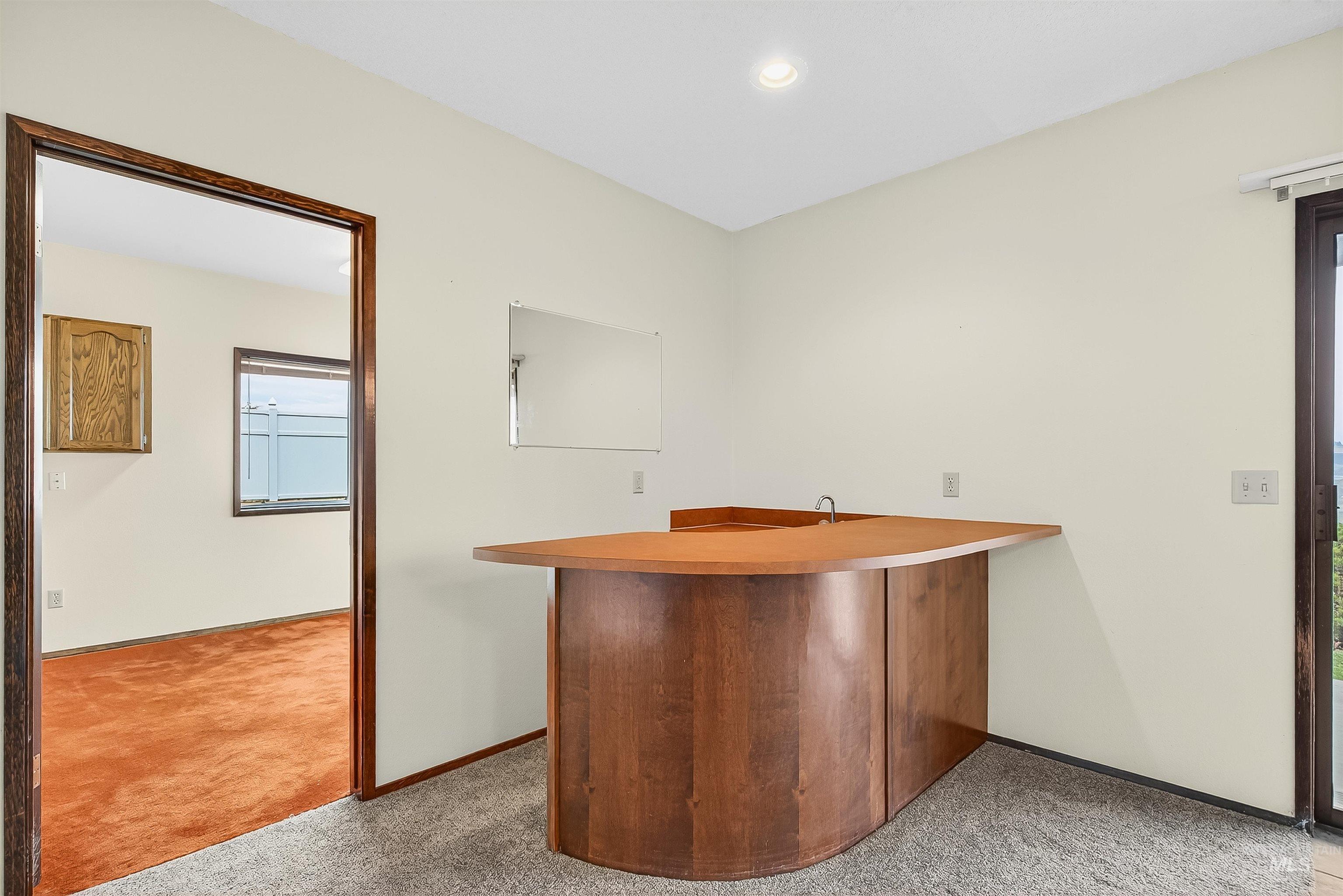 Indoor wet bar featuring light carpet and recessed lighting
