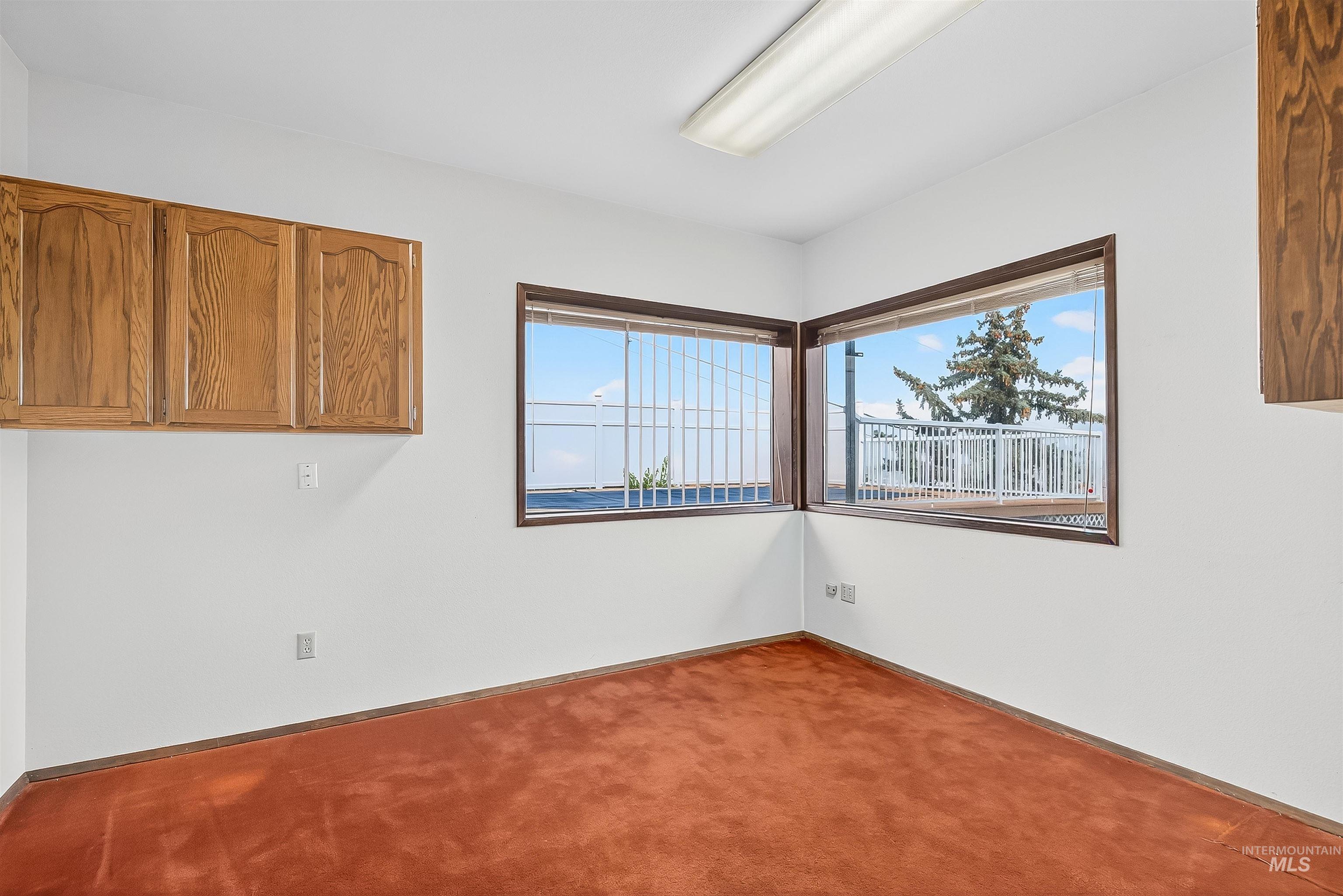 Carpeted spare room featuring baseboards