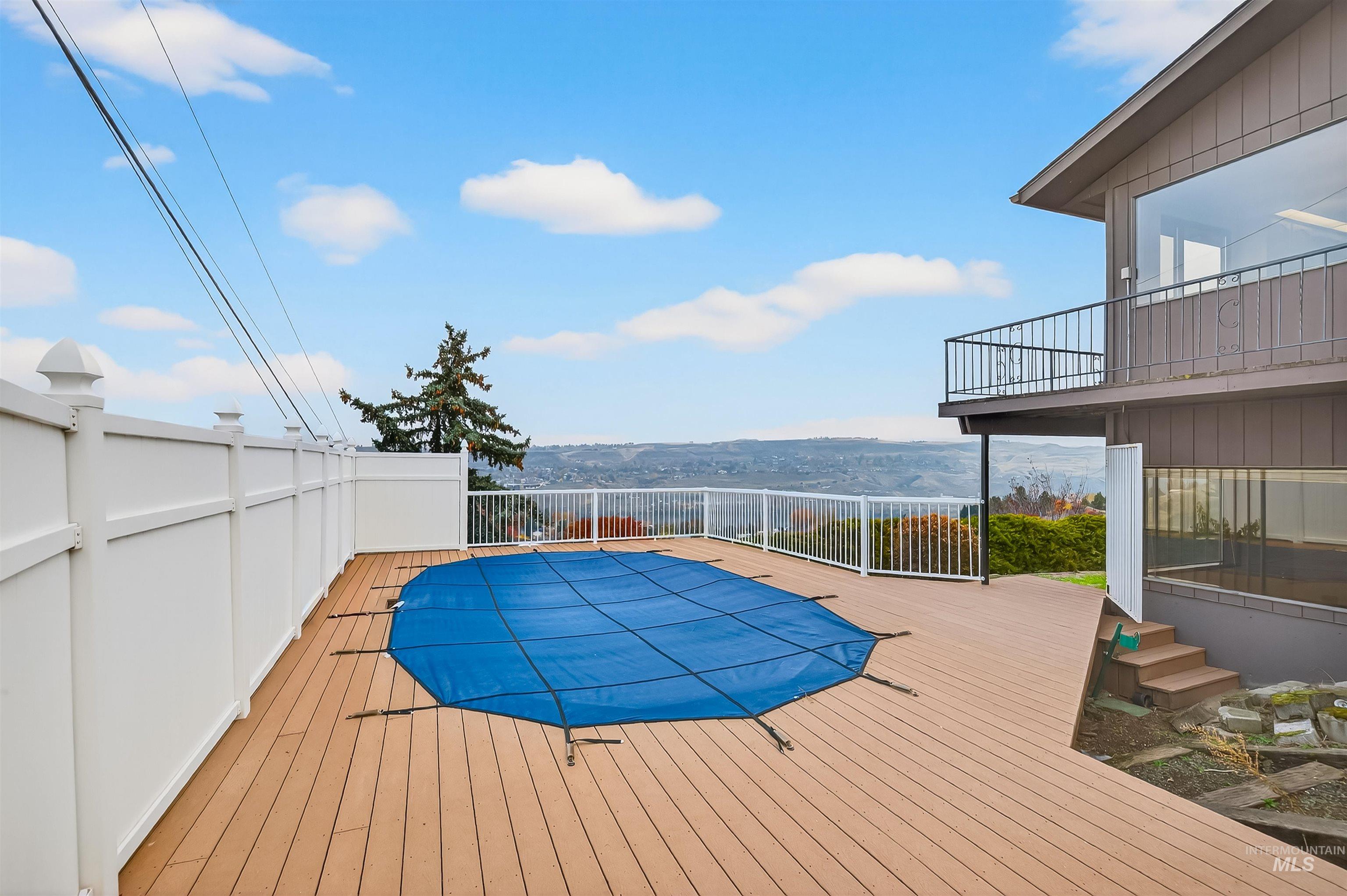 View of swimming pool with a rooftop deck and a balcony