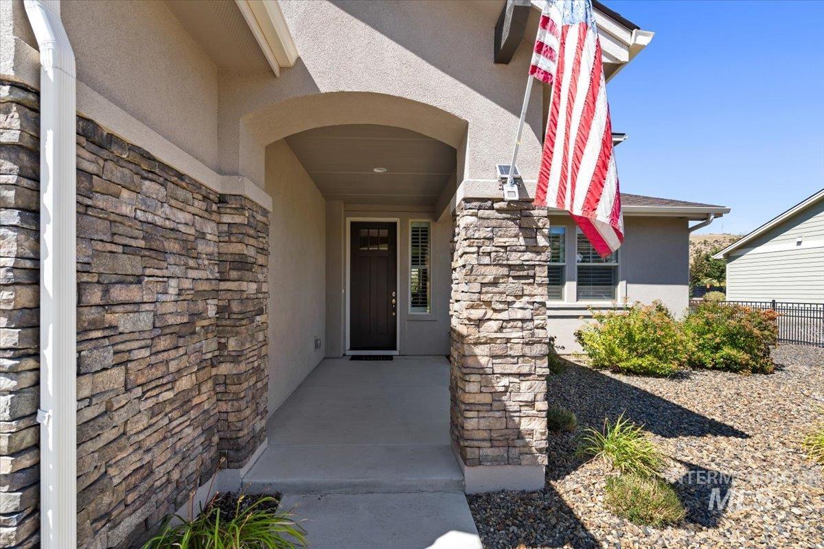View of exterior entry featuring stone siding and stucco siding