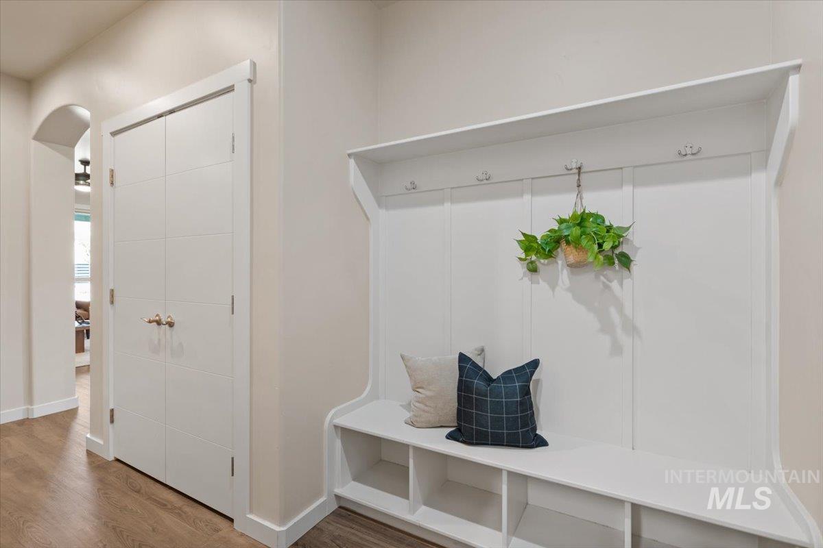 Mudroom with wood finished floors and arched walkways