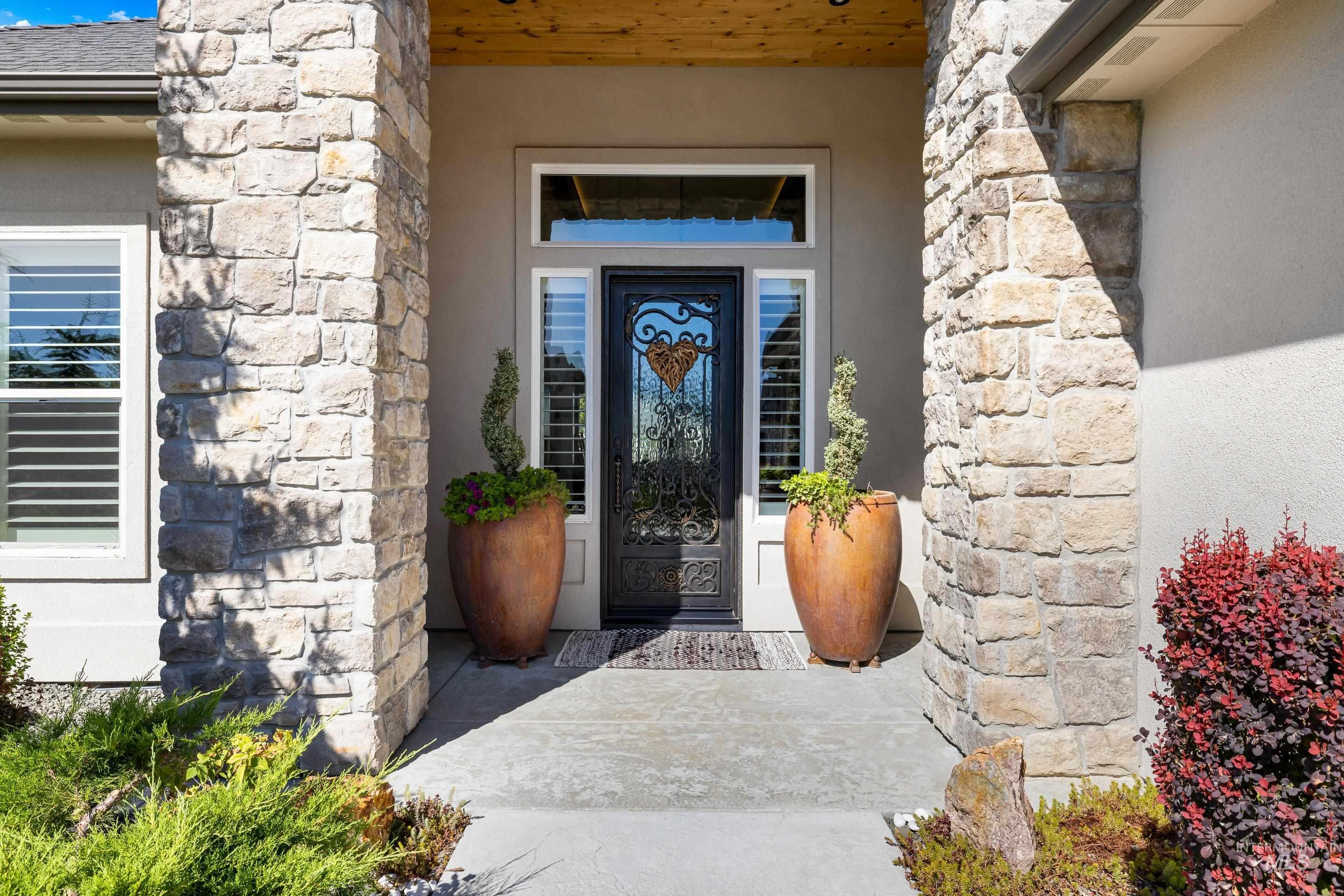 Entrance to property with stone siding and stucco siding
