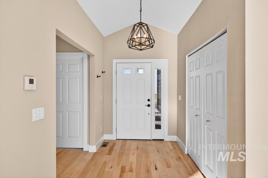 Foyer with lofted ceiling and light wood-style floors