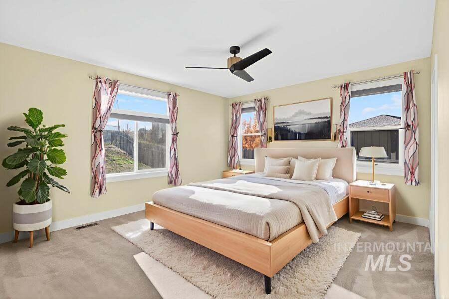 Bedroom with light carpet and a ceiling fan
