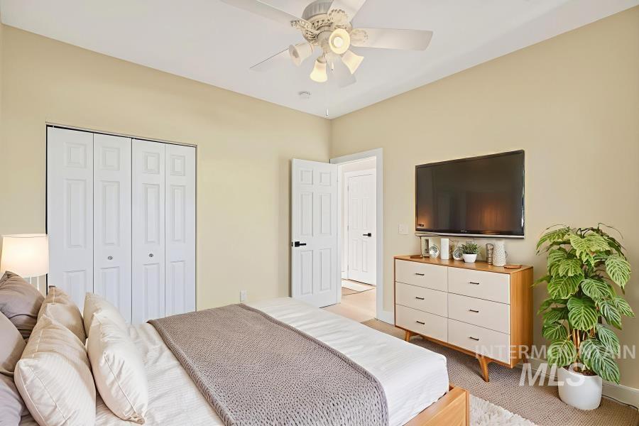 Bedroom featuring light carpet, ceiling fan, and a closet